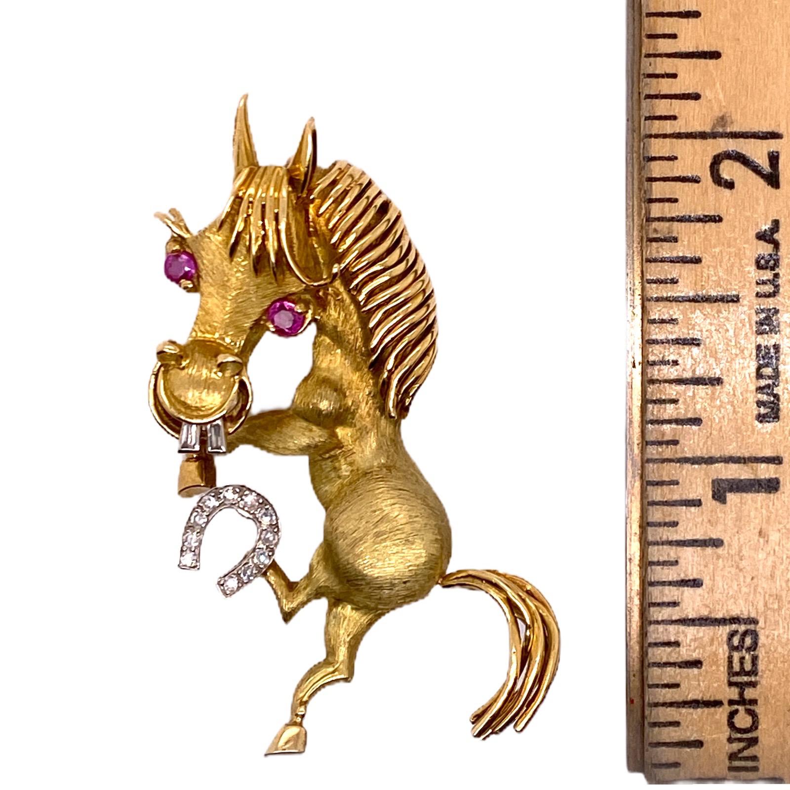 Adorable horse pin fashioned in 18 karat yellow gold. The brooch features 11 single cut and 2 baguette diamonds weighing .15 carat total weight. The brooch measures 2.0 inches in length, 1.0 in width, and features ruby eyes. 