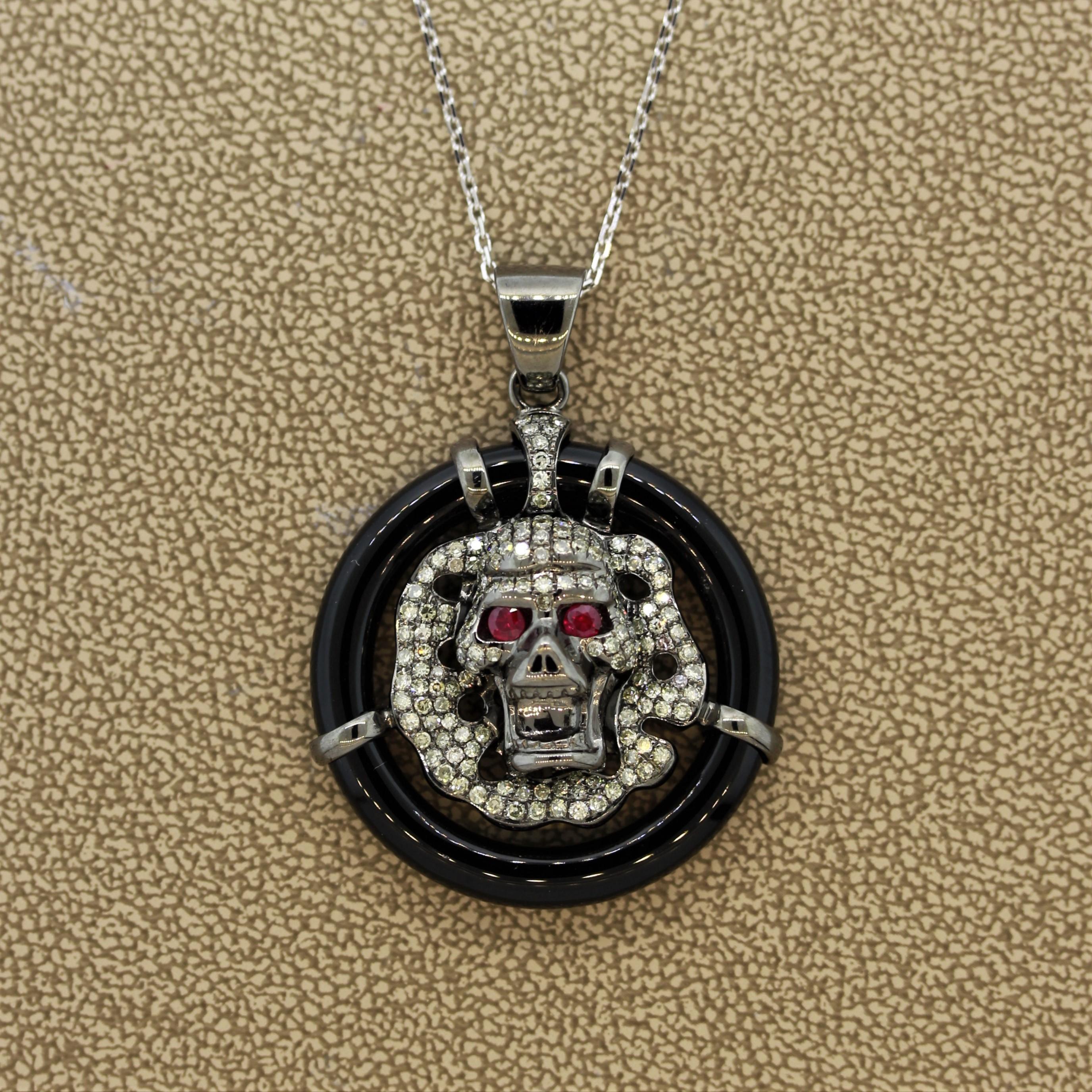 È vivo! Questo ciondolo presenta un teschio feroce con 1,16 carati di diamanti e 0,13 carati di rubini per gli occhi. Realizzato in oro 18 carati con una finitura in rodio nero che gli conferisce un aspetto metallico, è incorniciato da un pezzo
