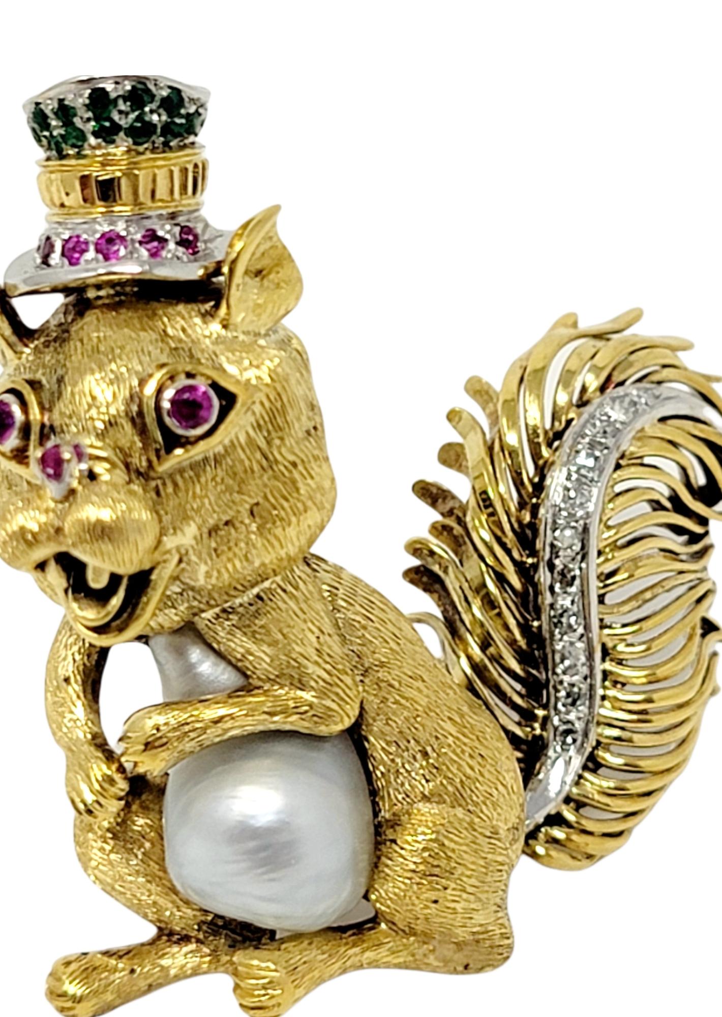 Stunningly detailed, top hat wearing squirrel brooch accented with glittering diamonds, rubies and emeralds. Made of solid 14 karat yellow and white gold, this charming little guy is also clutching a gorgeous silver baroque cultured pearl in his