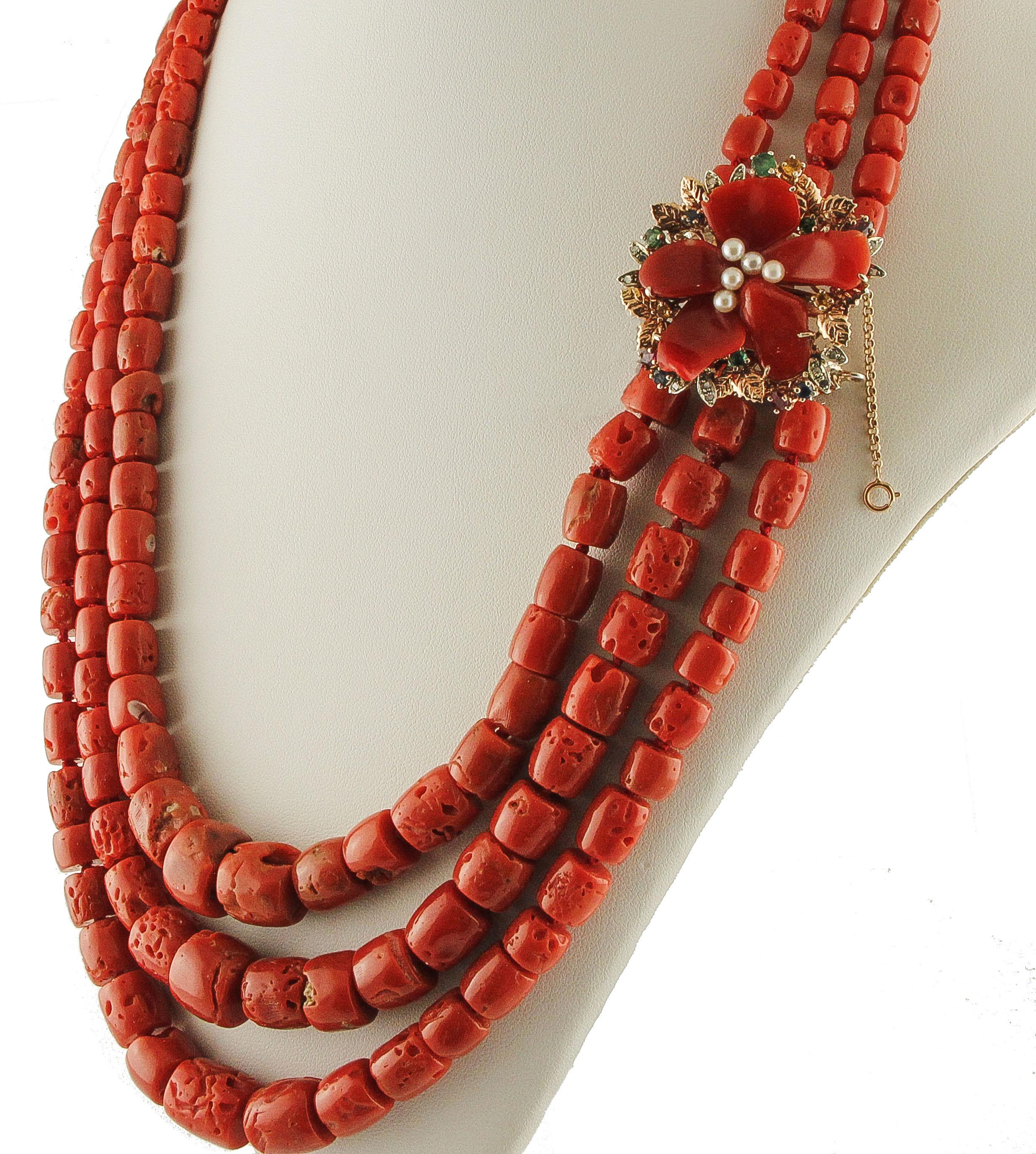 Elegant multi-strand necklace composed by three red coral rows and 9K rose gold and silver flower shape clasp mounted with five red coral petals, little white pearls in the center, rose gold and silver detailes adorned with diamonds, little rubies,