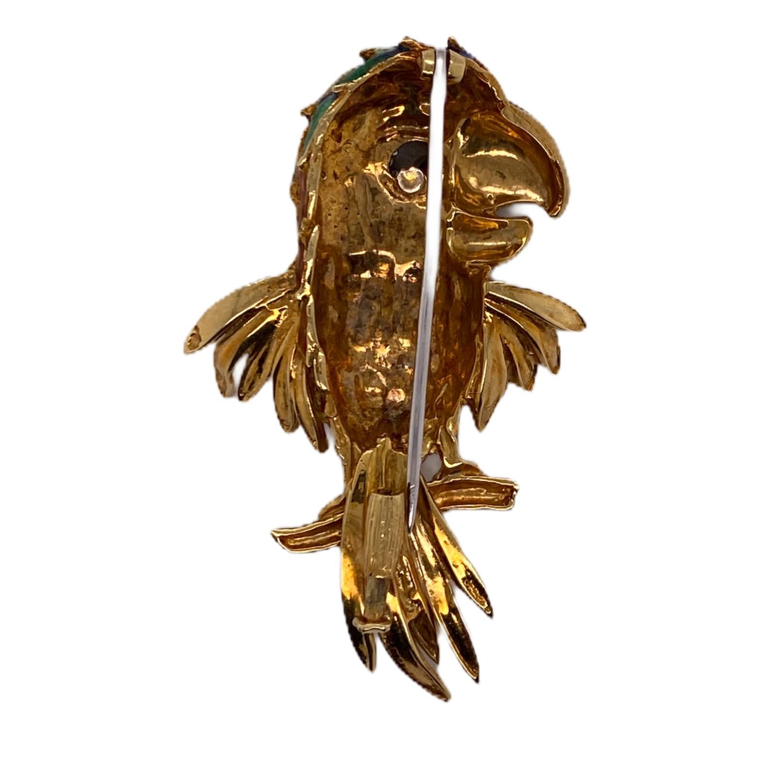 Colorful parrot brooch crafted in 18 karat yellow gold. The beautiful bird features colorful enamel, diamond, and ruby accents.  The parrot measures 1.5 x 2.25 inches. 