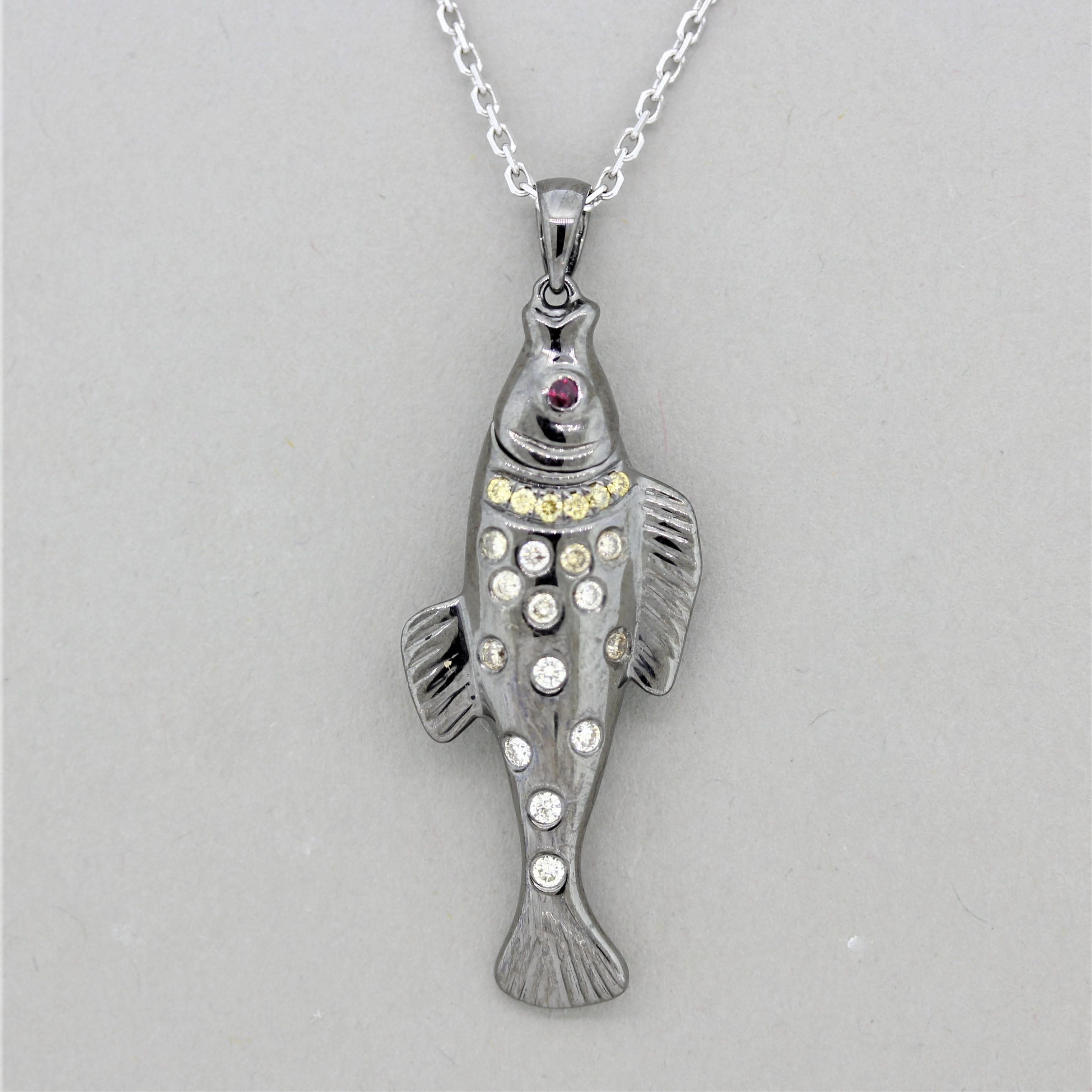 A lovely pendant of a wild fish! It is accented by 0.23 carats of round brilliant white and fancy yellow colored diamonds. Adding to that is a single round cut ruby used as the fish’s eye. The pendant is finished with a rhodium plating which gives