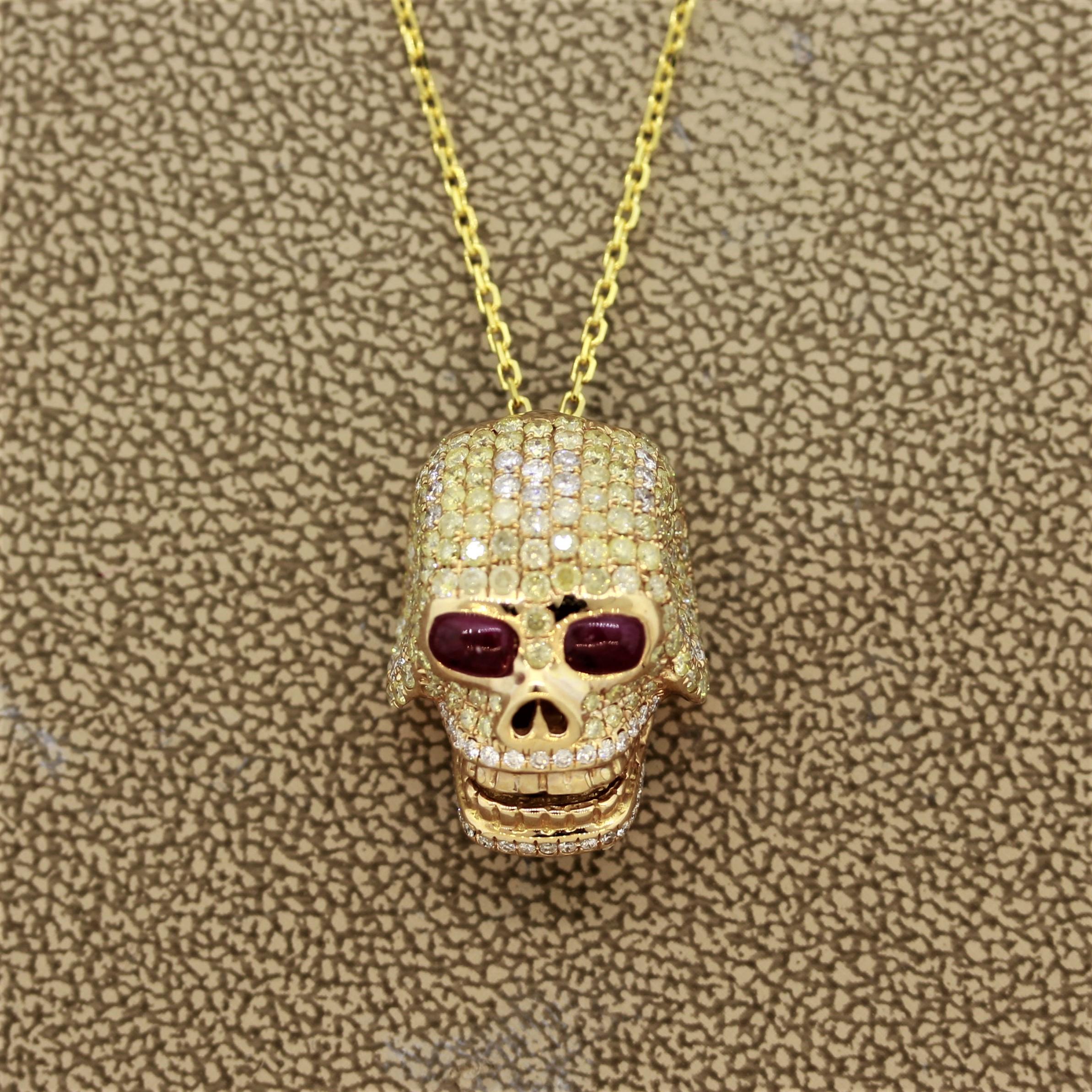 A gold skull pendant featuring 2.01 carats of round brilliant cut fancy colored diamonds. There are 2 ruby cabochons used as the eyes. Made in 18k yellow gold and comes with an 18k gold necklace.

Pendant Length: 0.75 inches

Necklace Length: 18