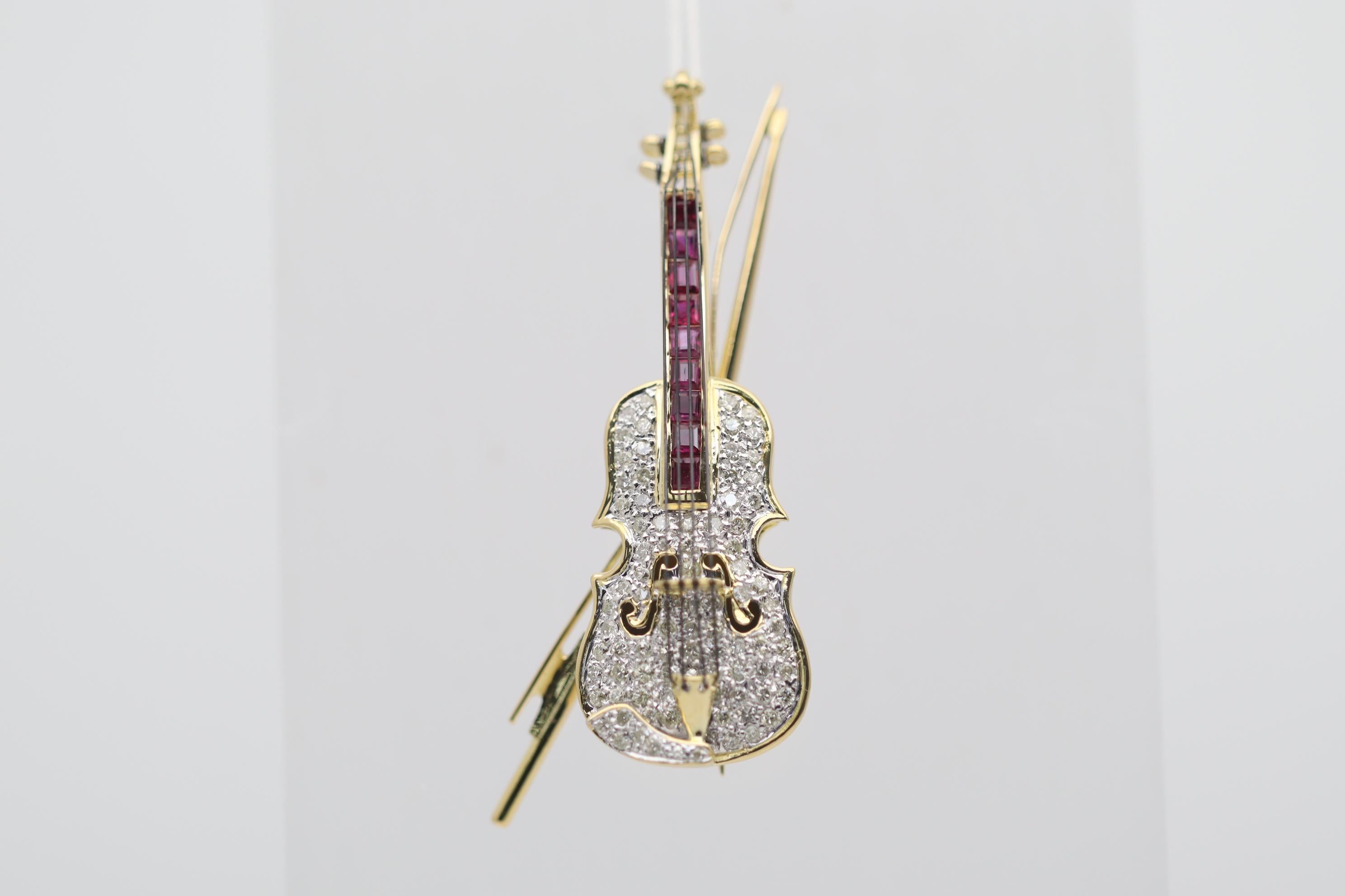 A diamond and ruby studded gold violin! It features 1.19 carats of round brilliant-cut diamonds along with 0.80 carats of square-cut rubies channel set under the violin’s strings. Made in 18k yellow gold and ready to be worn as a brooch or add a