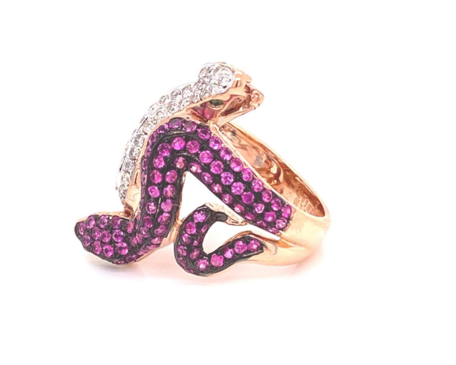 This is a stunning double snake ring, crafted from 18k rose and white gold with a polished finish featuring two snakes with head opposite end on the long part of the ring. One snake has rubies mounted in black rhodium with rose gold body and green