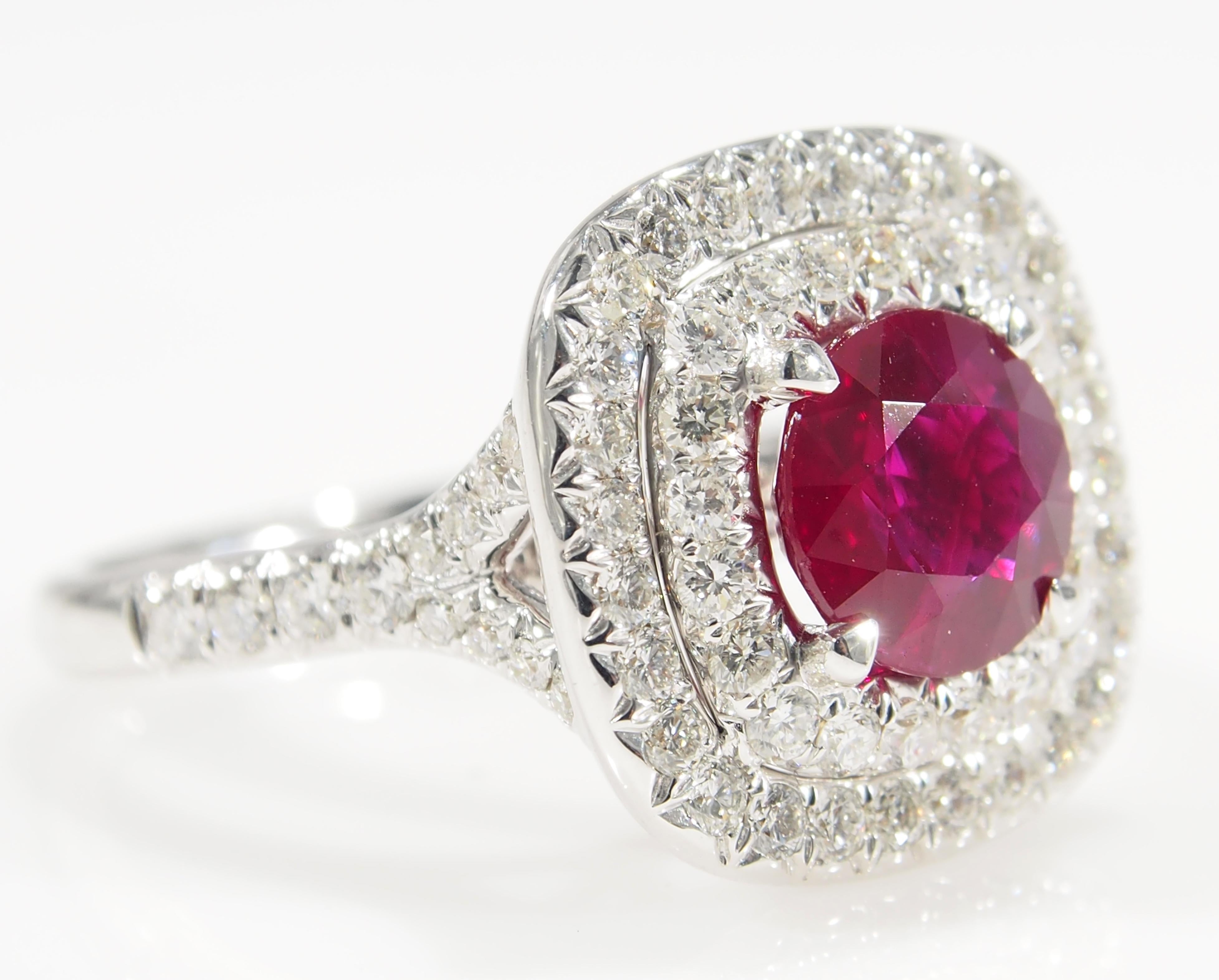 This is a classic 18K White Gold Diamond and Ruby Ring. There are (72) Round Brilliant Cut Diamonds set in a Double Halo and along the Shank for approximately 1.12ctw, G-H in Color, VS-SI in Clarity that accent the (1) Cushion Shape Ruby, 2.03ct. An
