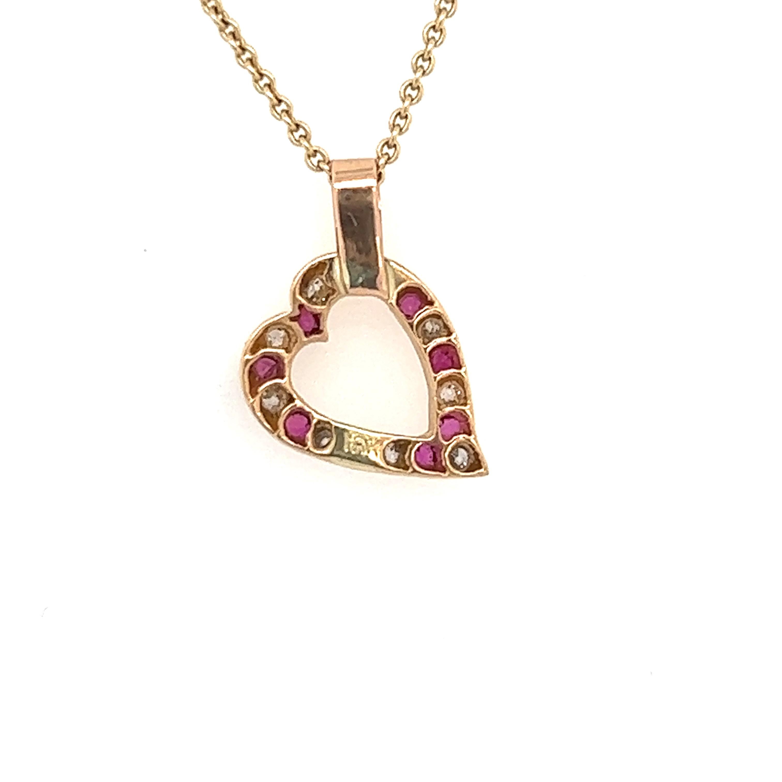 A petite heart pendant.  Comprised of alternating rubies and diamonds set at a jaunty angle.  18K yellow gold.  1/2