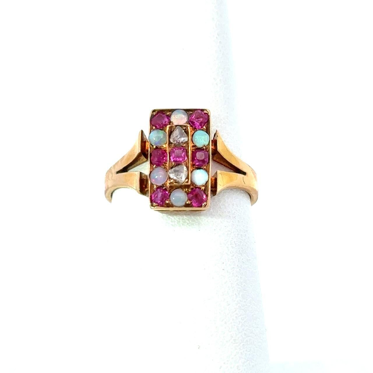 Antique Checkerboard Ring Late 1800s European made 
The Ring Contains
Diamonds
Rubies
Opals
18KT Rose Gold 
3.7 grams 
Size 6.5 
It is 1/2 Inch x 1/4 Inch

Why we love it: This delicate checkerboard ring is a piece of history, dating from the