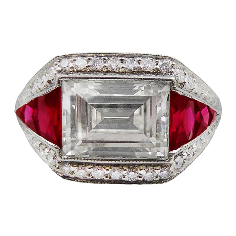 A beautiful cocktail ring decorated with a 2-carat emerald-cut diamond that's equivalent to K color, VVS2 clarity. The diamond is surrounded by tapered French-cut rubies and melee diamonds totaling to 1 carat.  
The mounting is made in platinum