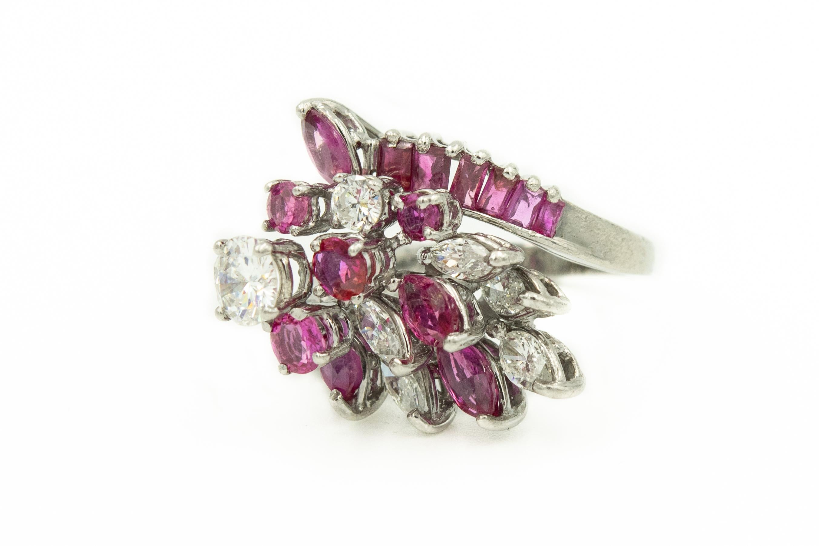Platinum diamond and ruby cocktail ring featuring with a .65c center diamond (VS2 H-I)  surrounded round and marquise diamonds and rubies with a band that has one side with baguette diamonds and the other with baguette rubies.  The ring is three