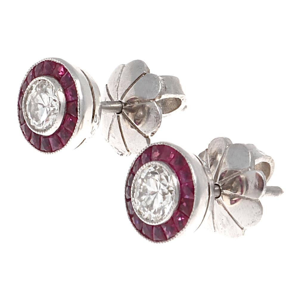 A colorful spin on diamond studs, featuring two old European cut diamonds that are 0.20 carats each, I-J color and SI2 clarity. There are 32 perfectly shaped French cut rubies framing each diamond that weigh approximately 1.08 carats total.  