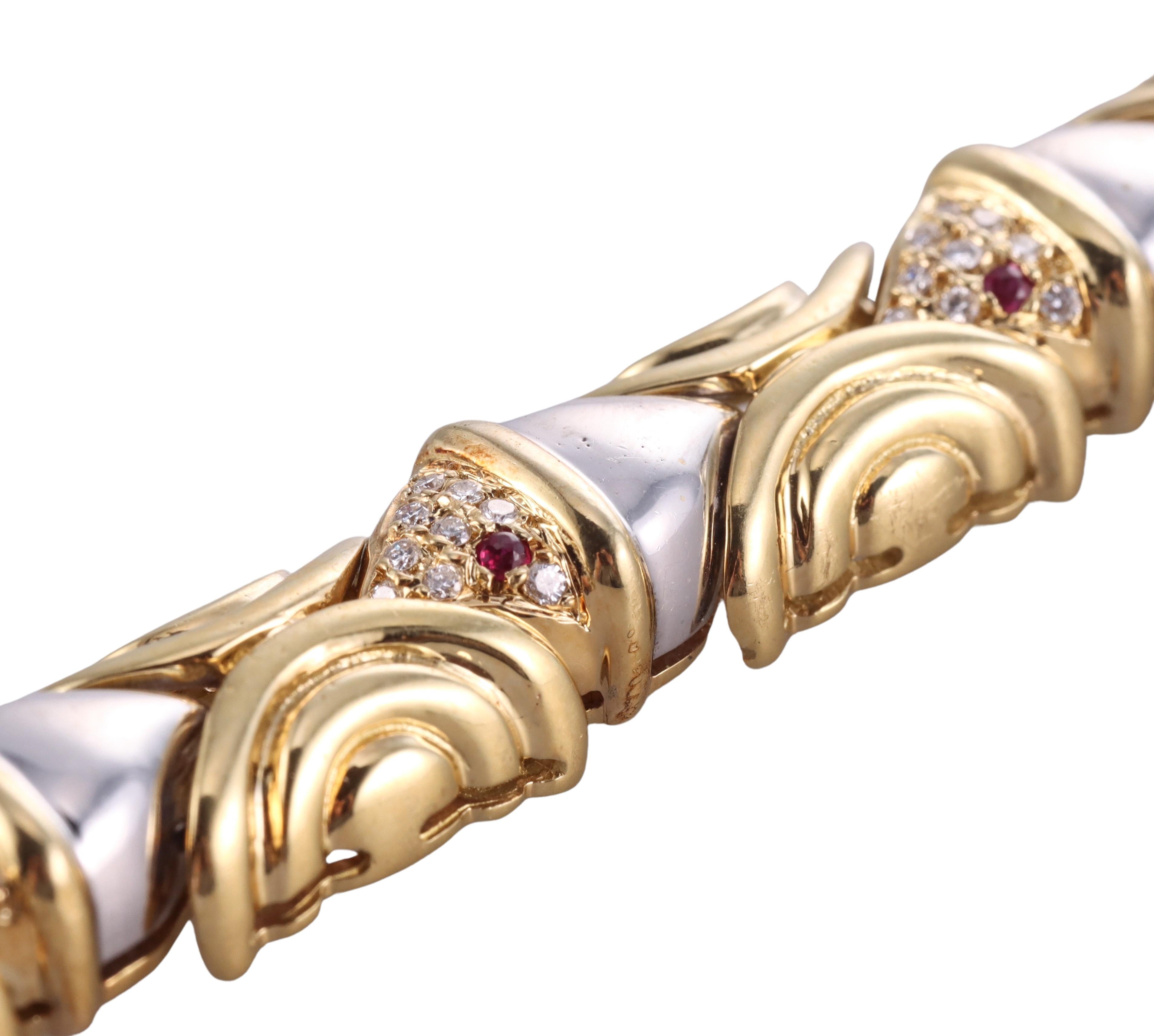 18k yellow and white gold fish motif bracelet, set with 0.45ctw H/VS diamonds and ruby eyes. Bracelet is 7