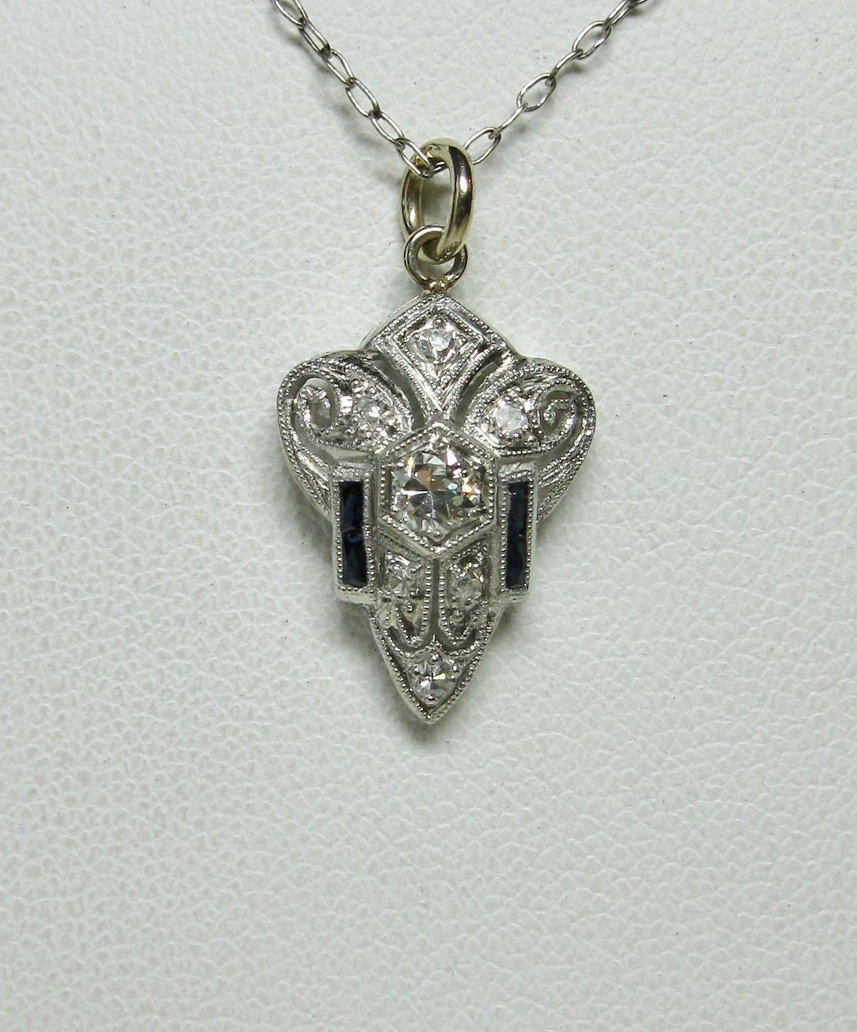 A stunning antique Art Deco - Victorian - Edwardian Diamond Sapphire Lavaliere Pendant in 18 Karat White Gold.  The beautiful pendant has a central sparkling white diamond of approximately .15 Carat.  This is surrounded by six additional diamonds as