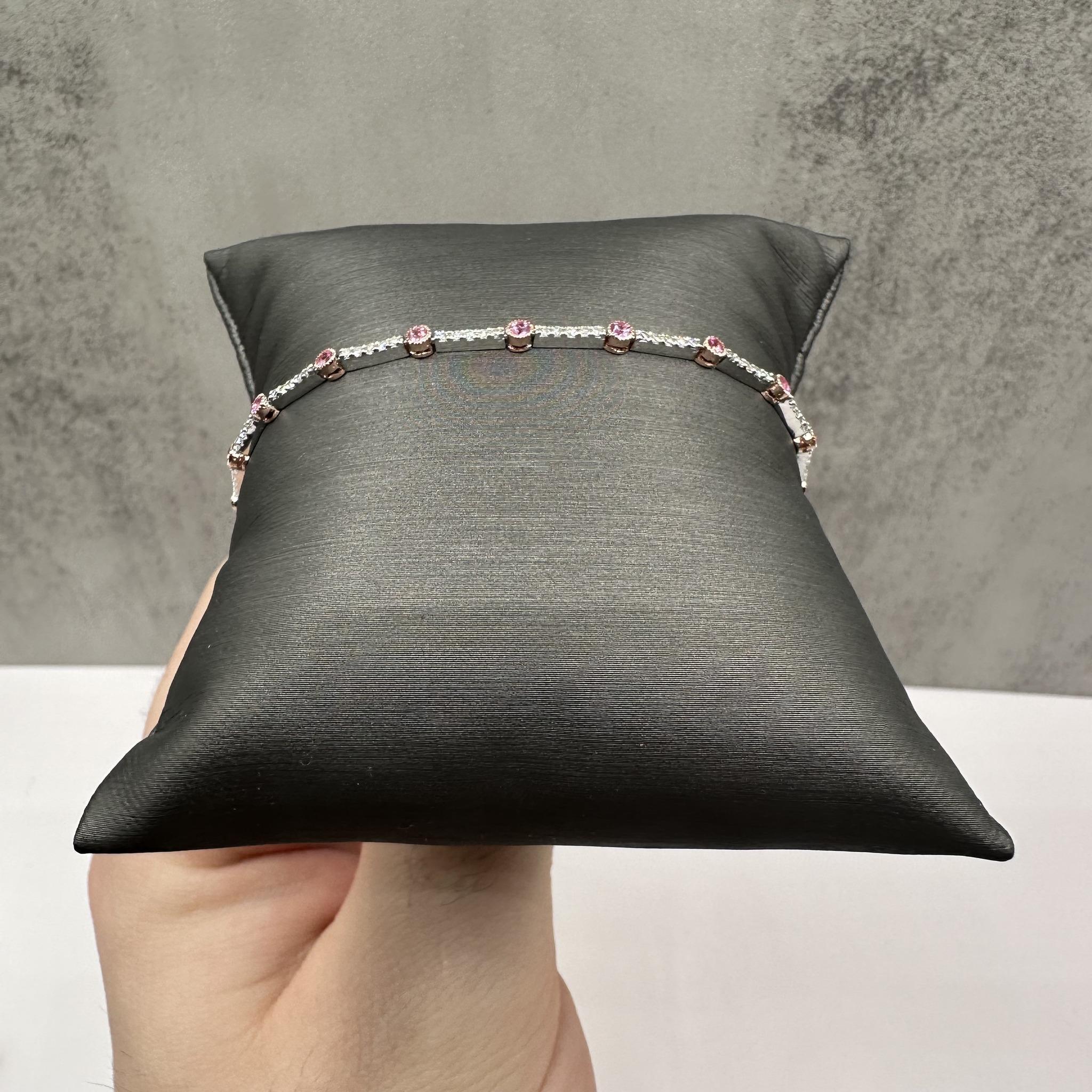 Cet exquis bracelet de diamants et de saphirs en or bicolore 18kt présente une combinaison étonnante de diamants ronds naturels de couleur GH et de pureté SI d'un poids total de 0,70 carat (ctw) et de saphirs roses ronds vibrants d'un poids total de