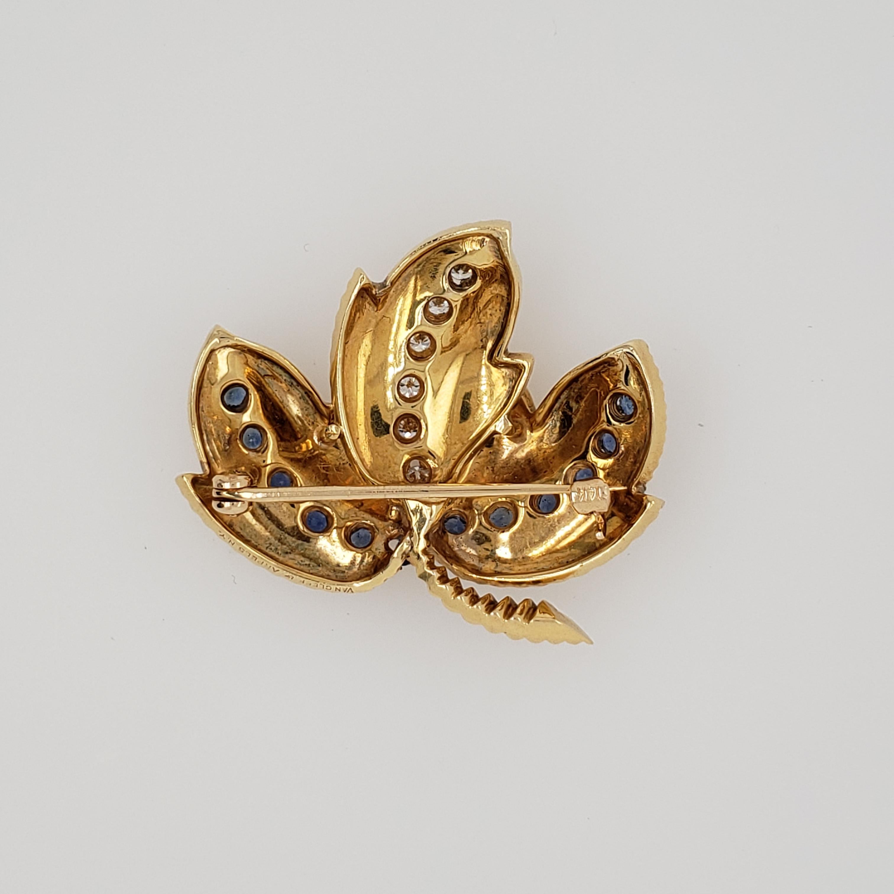 18kt Yellow Gold Maple Leaf Brooch signed Van Cleef & Arpels. Circa: 1970s. 6 Round Brilliant cut Diamonds = .36 carats total (2.5mm width for each). They are G in Color & VVS in Clarity. There are also 12 Sapphires = 1.08 carats total (.09 cts