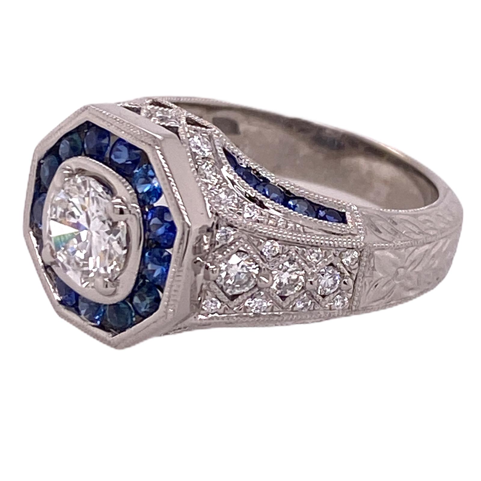 Stunning diamond and sapphire engagement ring fashioned in 14 karat white gold. The center round brilliant cut diamond weighs .75 carats and is graded G color and VVS clarity. The diamond is surrounded by 20 round blue sapphires and another 40 round
