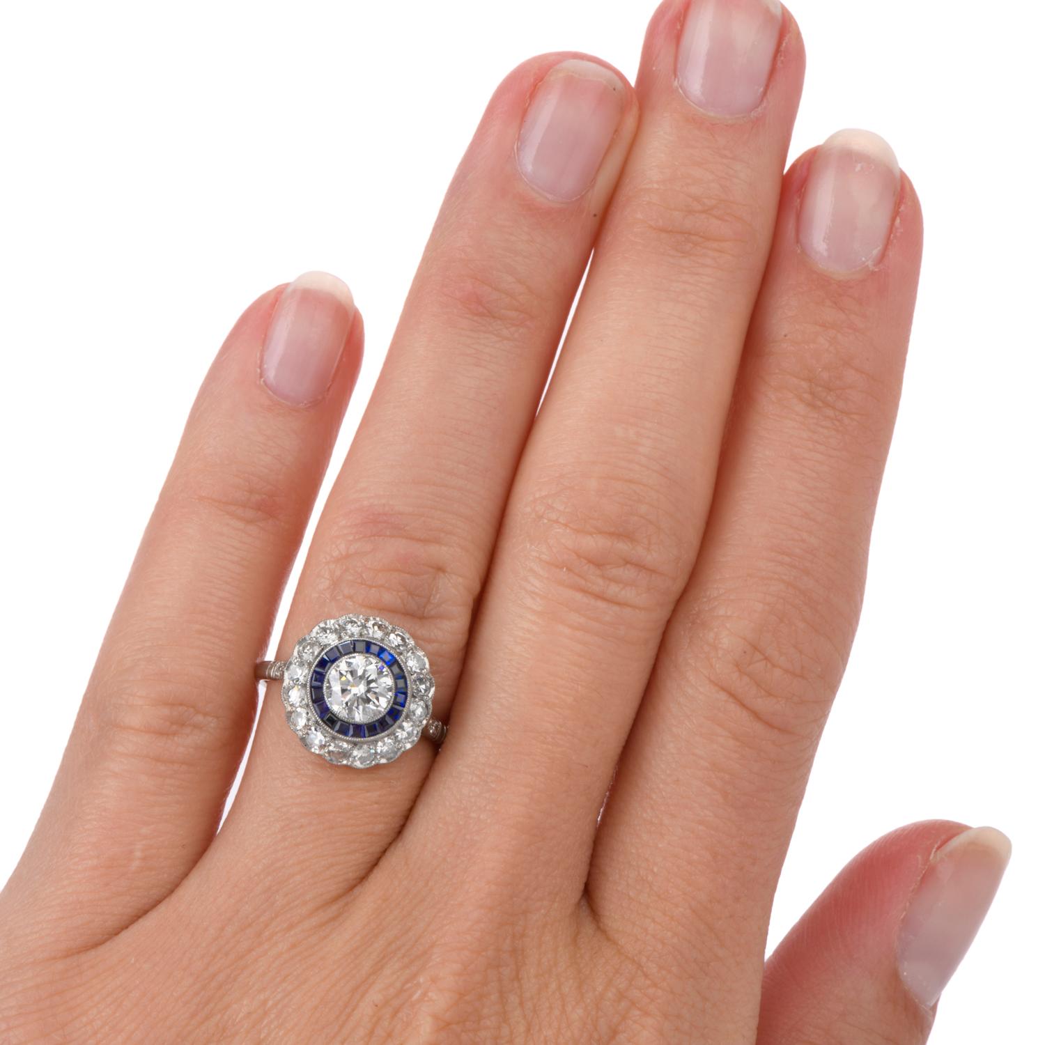 This right hand engagement or Cocktail Ring was inspired in a Double Halo

and crafted in Platinum. A bright white round brilliant cut Diamond is bezel set in the center with a rings of bezel set Sapphire and prong set round Diamonds surround.
