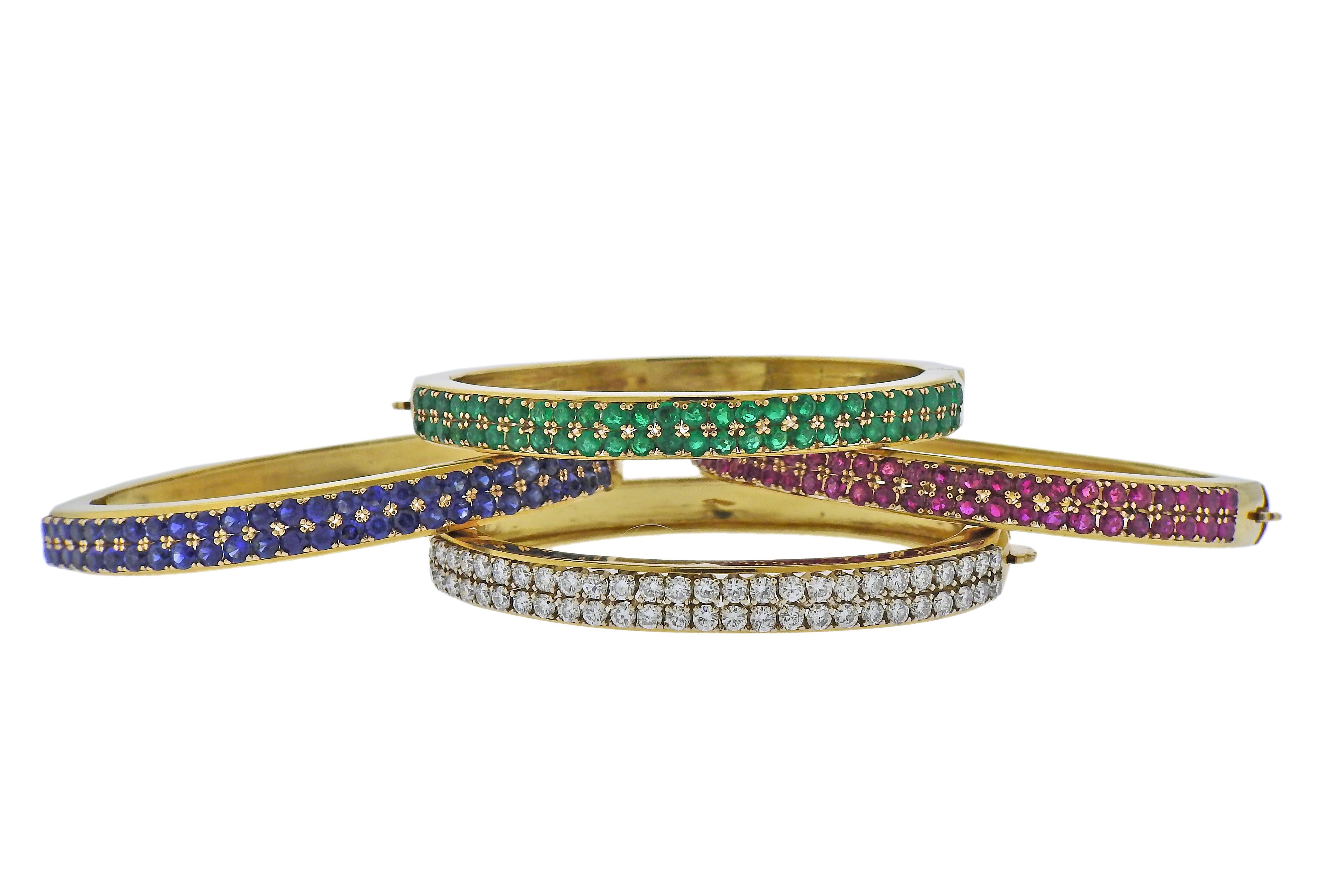 Set of four 18k gold bangle bracelets, featuring sapphires, rubies, emeralds and approx. 3.20ctw in diamonds. Each bracelet will fit approx. 6.75