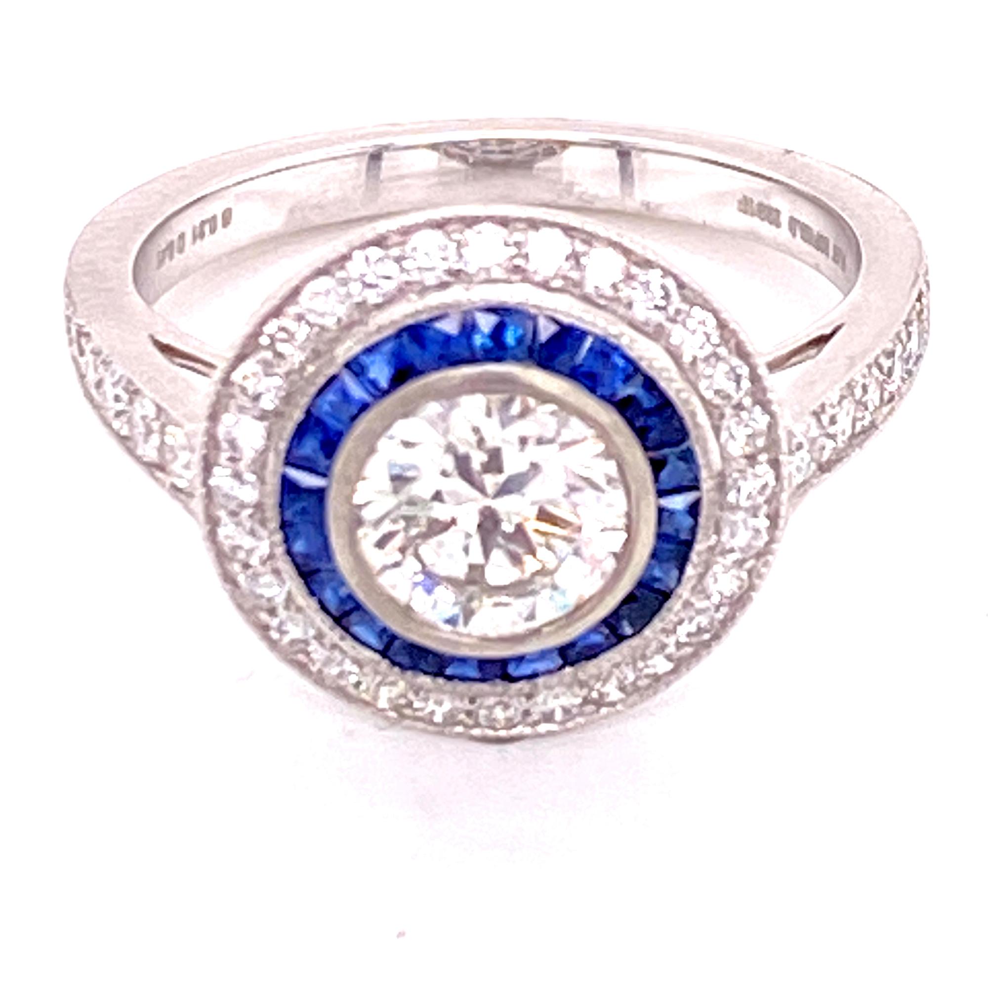 Beautiful Deco Style engagement ring fashioned in platinum. The round briliant cut diamond weighs .82 carats and is graded H color and I1 clarity. The mounting features a halo of blue sapphires surrounded by an outer halo of round brilliant cut