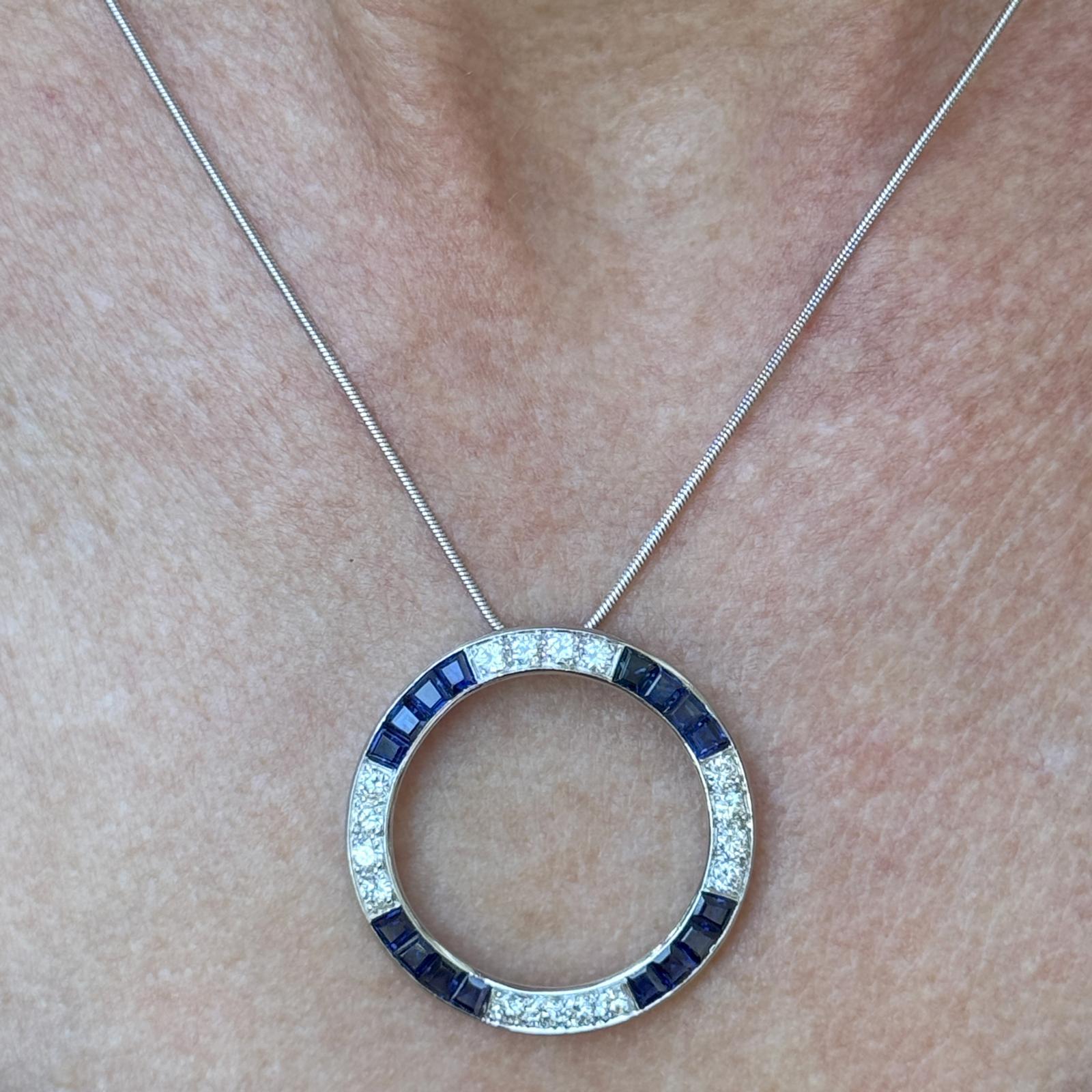 Dieser elegante und zeitlose Anhänger aus Platin mit offenem Kreis zeigt 16 Diamanten mit rundem Brillantschliff von insgesamt ca. 2,50 Karat (Farbe G-H, Reinheit VS2), die sich mit 12 satten blauen Saphiren abwechseln. Das klassische Kreismotiv mit