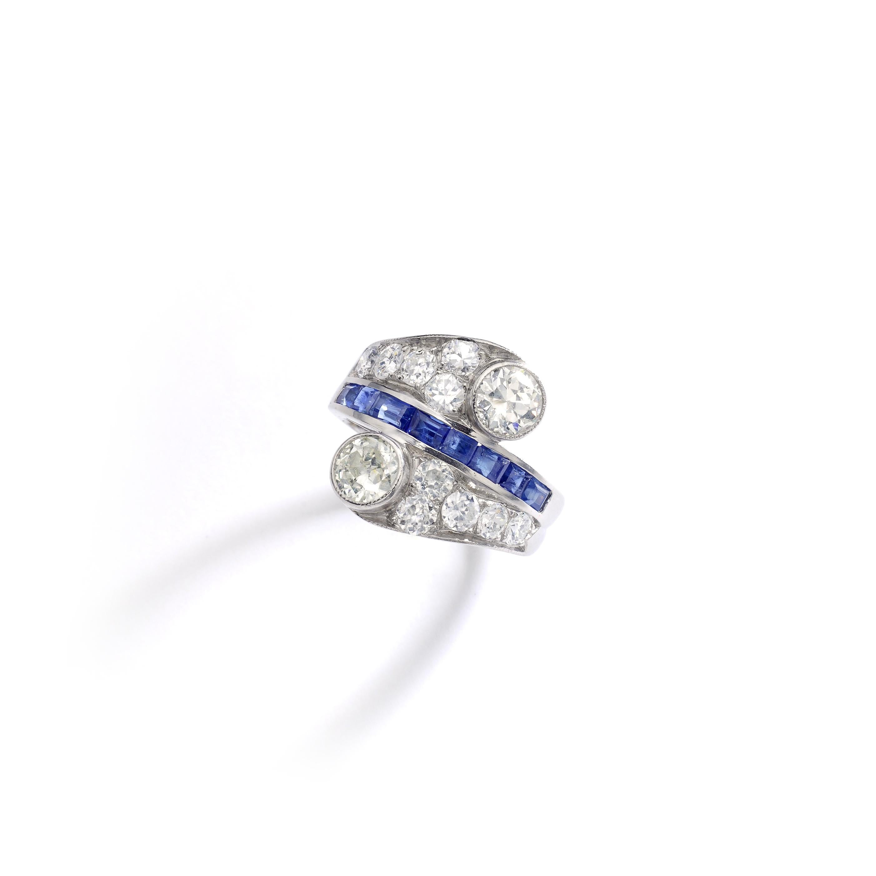 This 'Vous et Moi' ring is all in platinum set by Old-mine cut diamond. Two diamonds are more significant and separated by a calibrated Blue Sapphire line.
Total Diamond weight: approximately 2.50 carats.

Ring size: 6 1/4.
Complimentary ring size