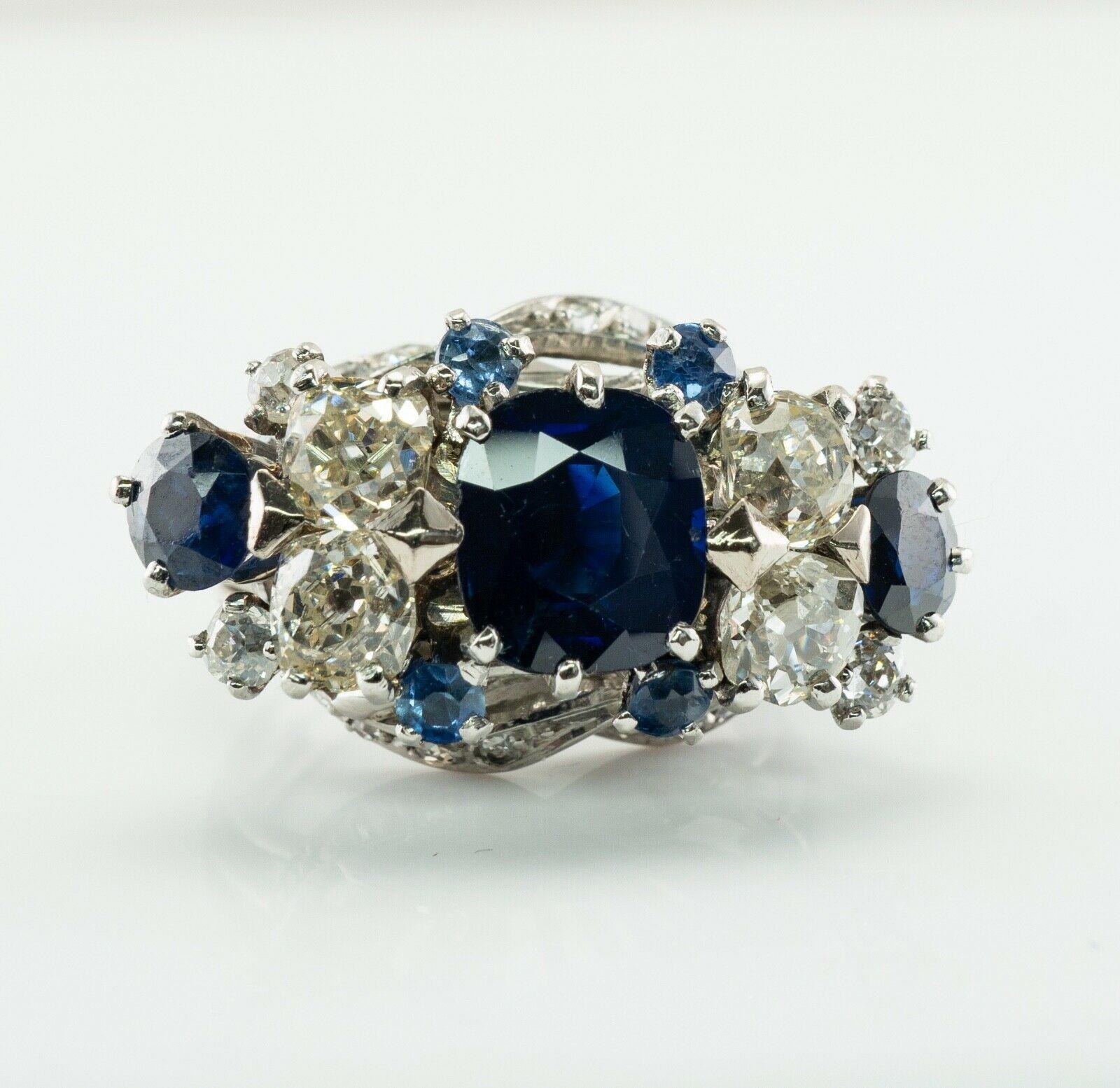 This vintage ring is finely crafted in solid 18K White Gold (carefully tested and guaranteed). The center natural Earth mined Sapphire measures 9x7mm (2.20 carats). Two round cut sapphires are 5mm each. These gems are intense dark blue stones. They