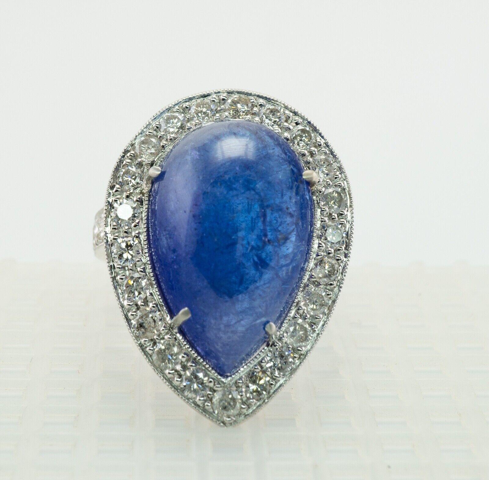 This stunning vintage ring is finely crafted in solid luxurious Platinum and set with genuine Earth mined Sapphire cabochon and diamonds. The center pear cut Sapphire measures 18mm x 12mm (16.33 carats). It has a violet undertone, natural inside