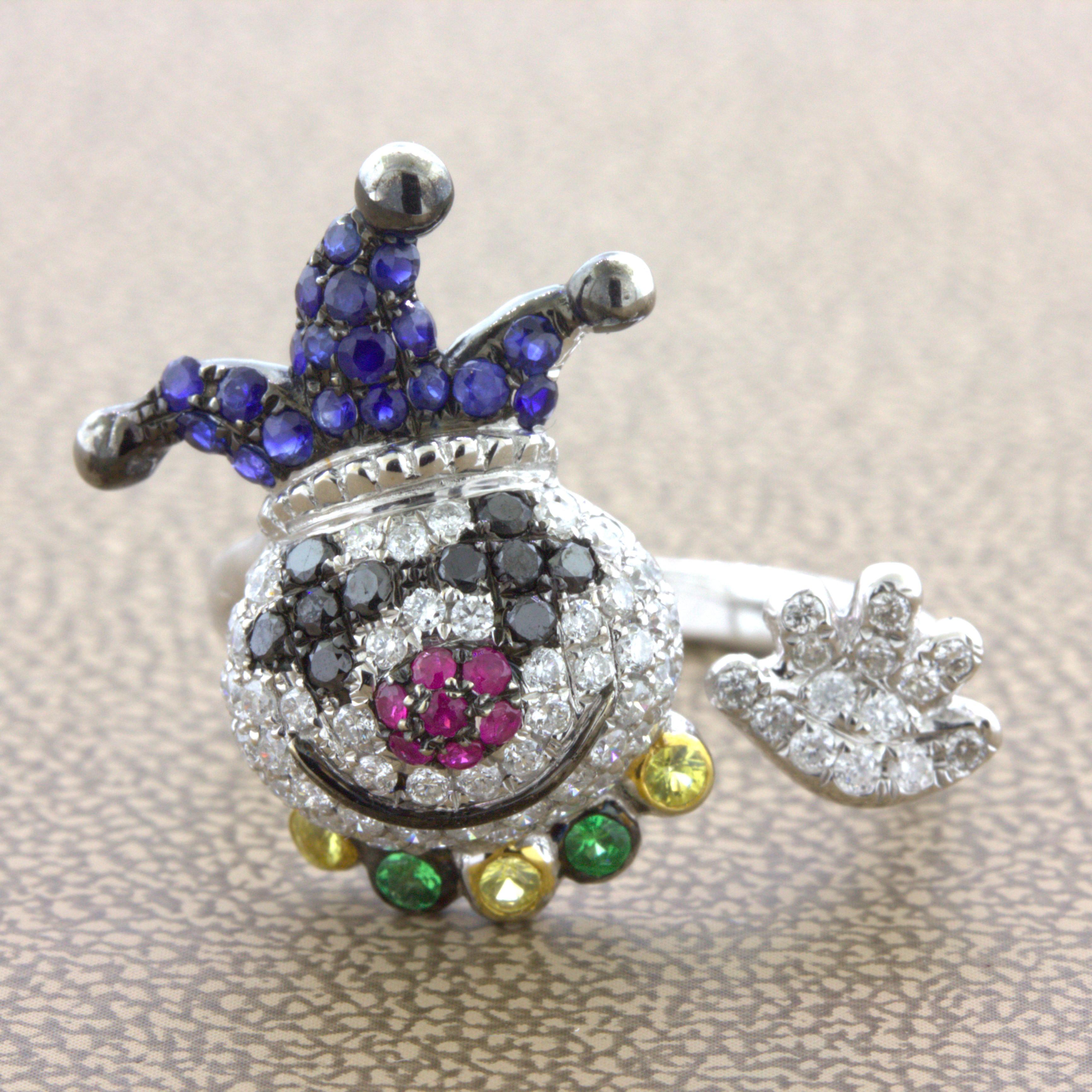 A fun and friendly clown studded in diamonds and colored gemstones. The smiling clown features 0.90 carats of white and black diamonds making its face, eyes, and hand along with 0.48 carats of rubies and sapphires which make its hat and nose. It has