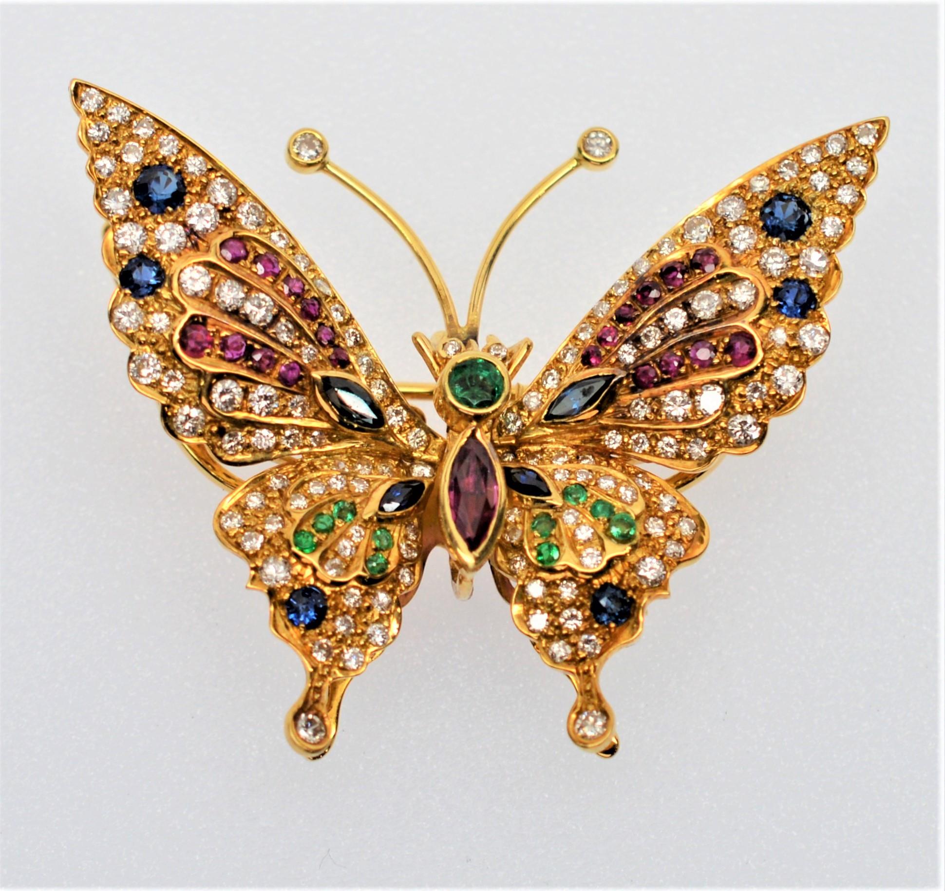 A rainbow of precious diamonds, rubies, emeralds and sapphires dress the colorful wings of whimsical eighteen karat yellow gold (18k) butterfly brooch.
The three dimensional construction with enhanced fluttering wings allows for unique movement and