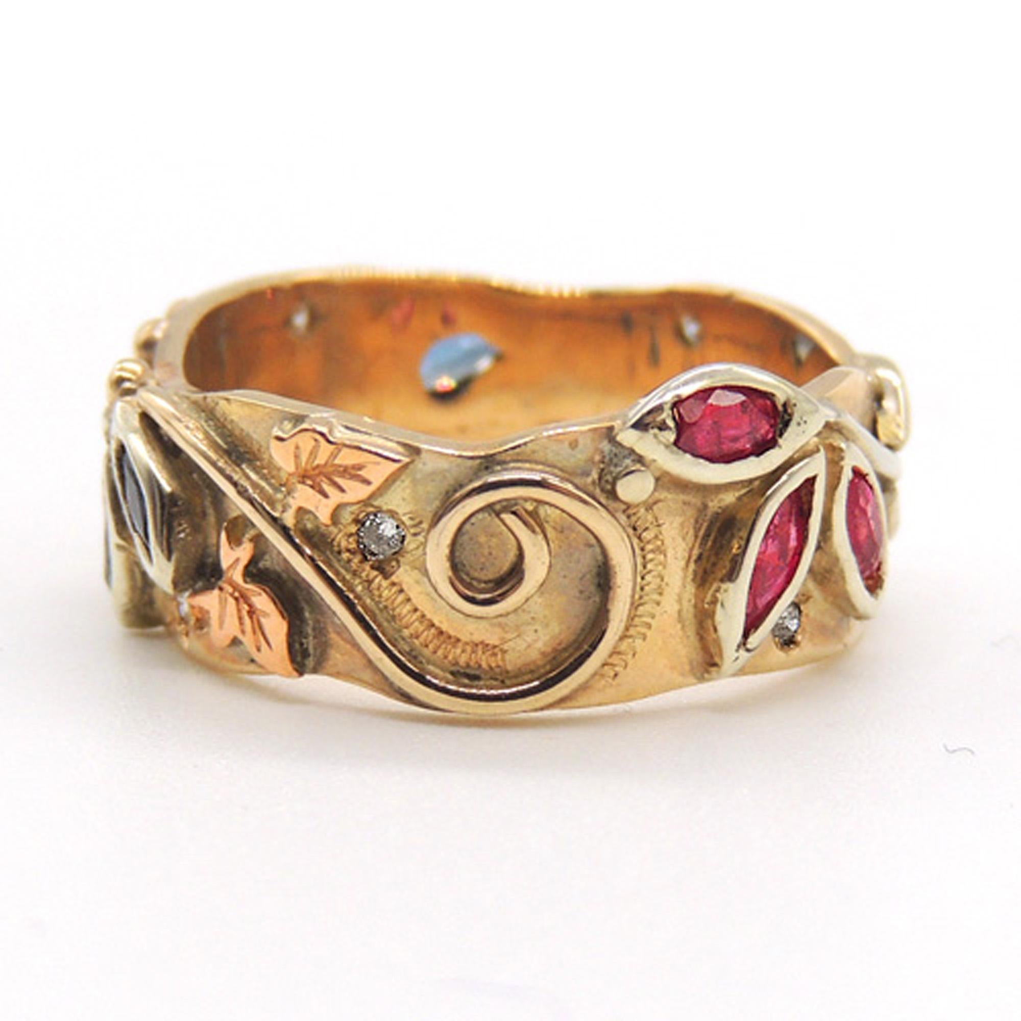 This is a beautiful handmade ring with a unique Autumnal 'art nouveau' design.

The ring is totally handmade in 9k yellow, white and rose gold.
It is set with good quality rubies, sapphires and diamonds all the way round.

The ring is a size P1/2