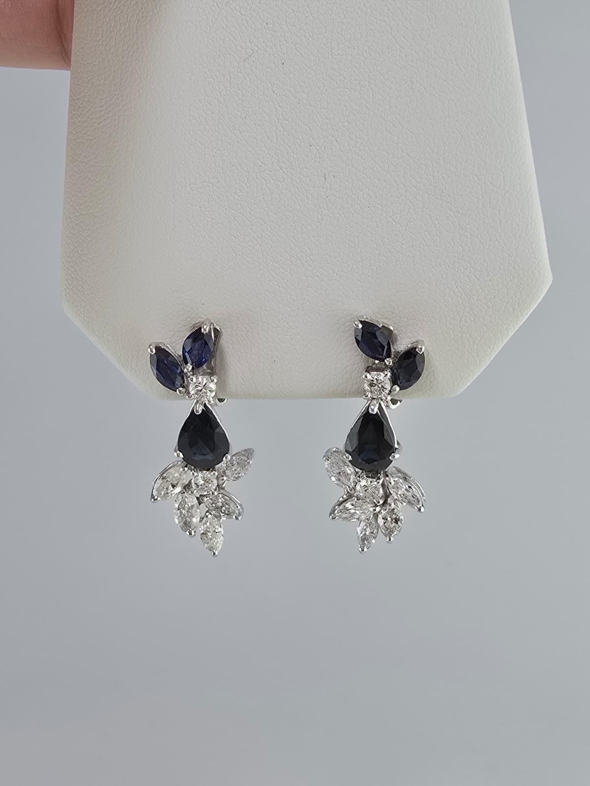 Expression frappante d'une élégance intemporelle, cette parure de saphirs et de diamants est composée d'un superbe or blanc 18 carats de 58 grammes finement travaillé, orné d'un total de 35 carats de saphirs naturels et de 14,55 carats de diamants