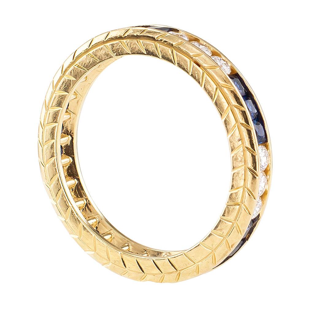 Diamond sapphire and yellow gold eternity ring.

DETAILS:
Eternity gold ring continuously set with alternating trios of channel-set diamonds and blue sapphires.
Fifteen round brilliant-cut diamonds totaling approximately 0.50 carat, approximately H