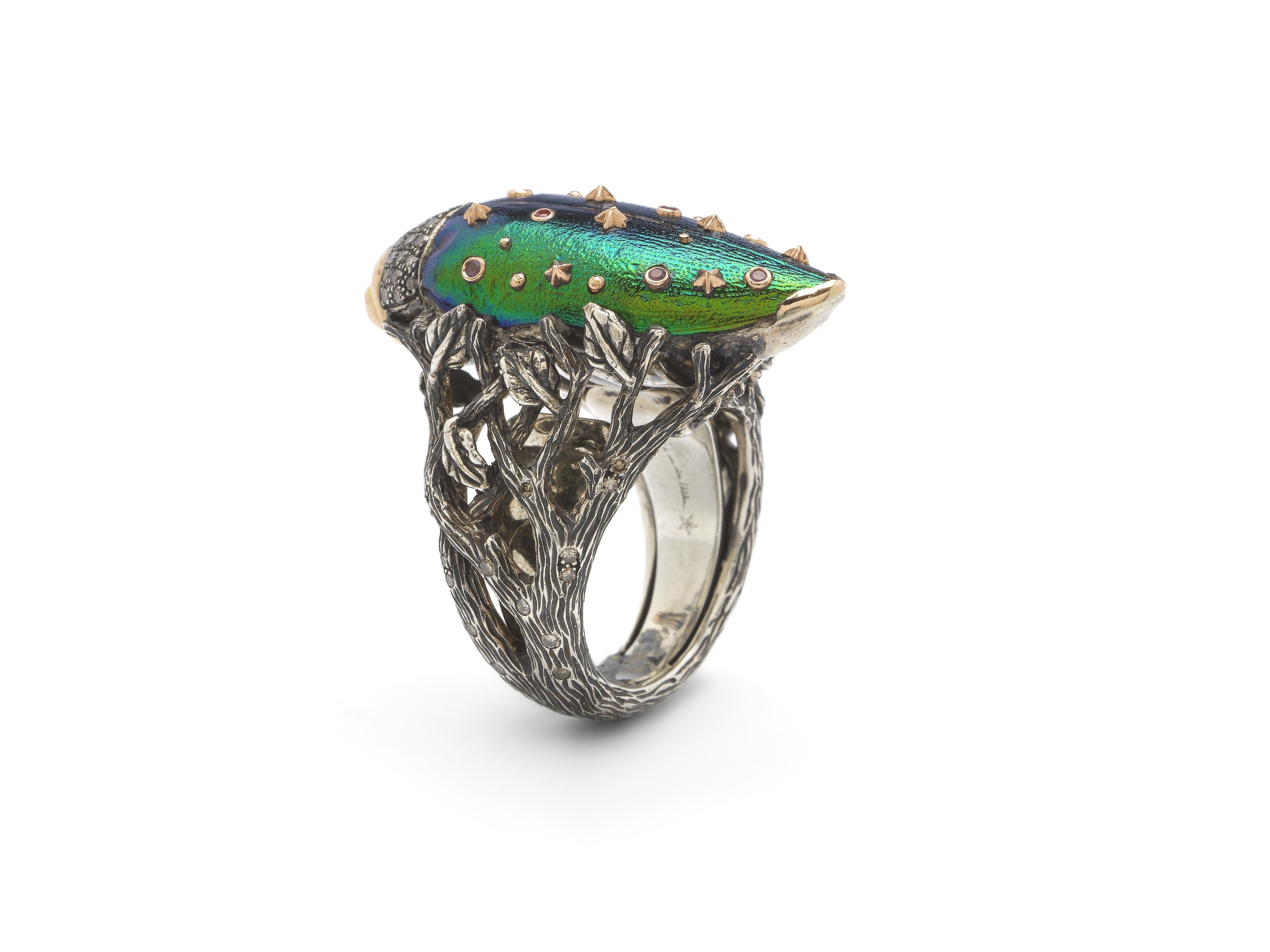 This cocktail ring shimmers with brooding tones that evoke the colours of the evening sky. The piece is designed in 18k rose gold and sterling silver, with the scarab beetle set with brown diamonds and green tsavorite eyes. Its blue-toned real