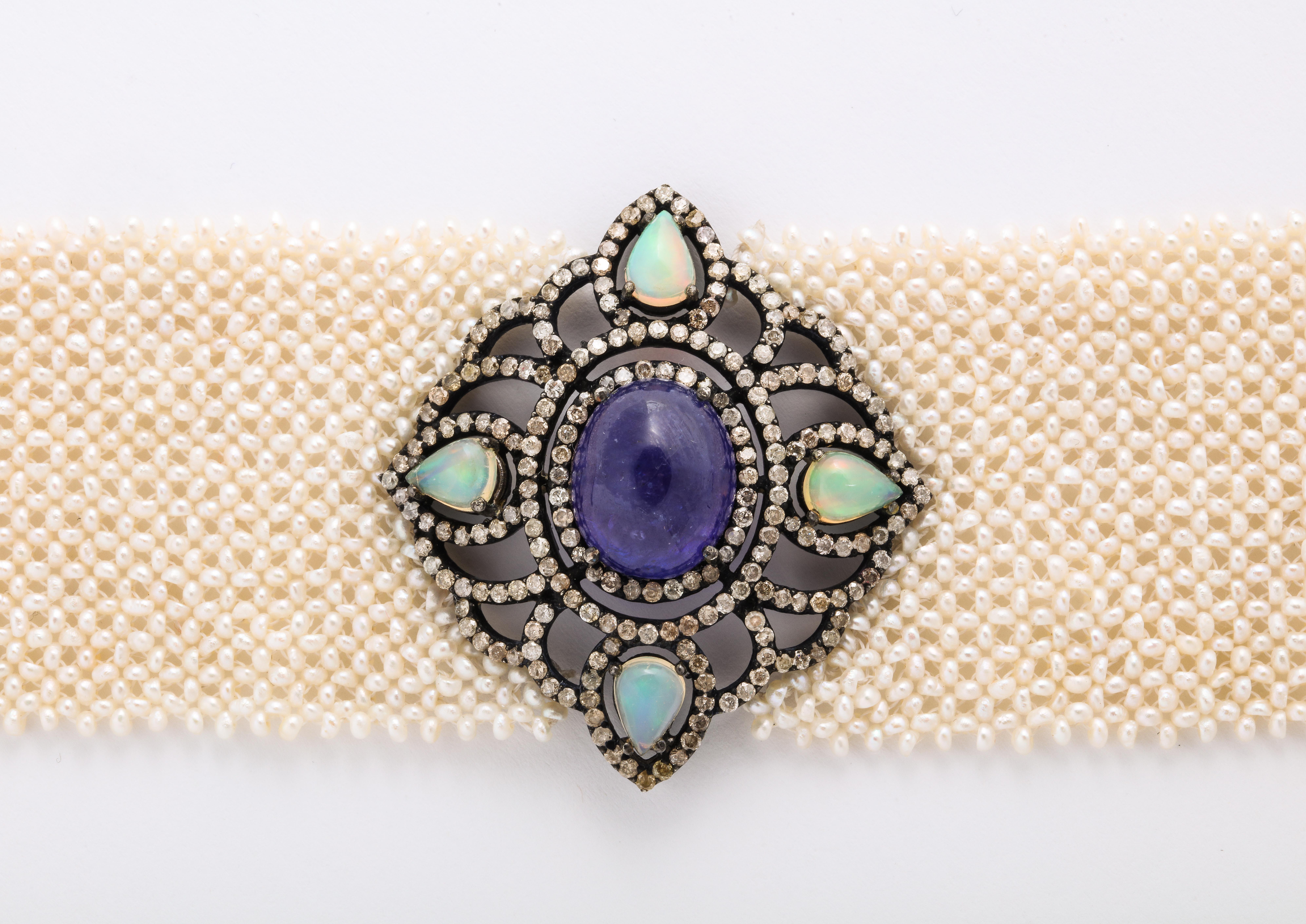 Diamond and seed mesh pearl bracelet in sterling, circa 2000. 7 1/4 inches long x 1 1/2 inches wide.

Materials:
Tarnished sterling
Gold clasp
22.0 dwt 

Stones
Hand strung seed pearl mesh, Ethiopian opal 
Pear cabochons 1.20 tw
Oval sapphire