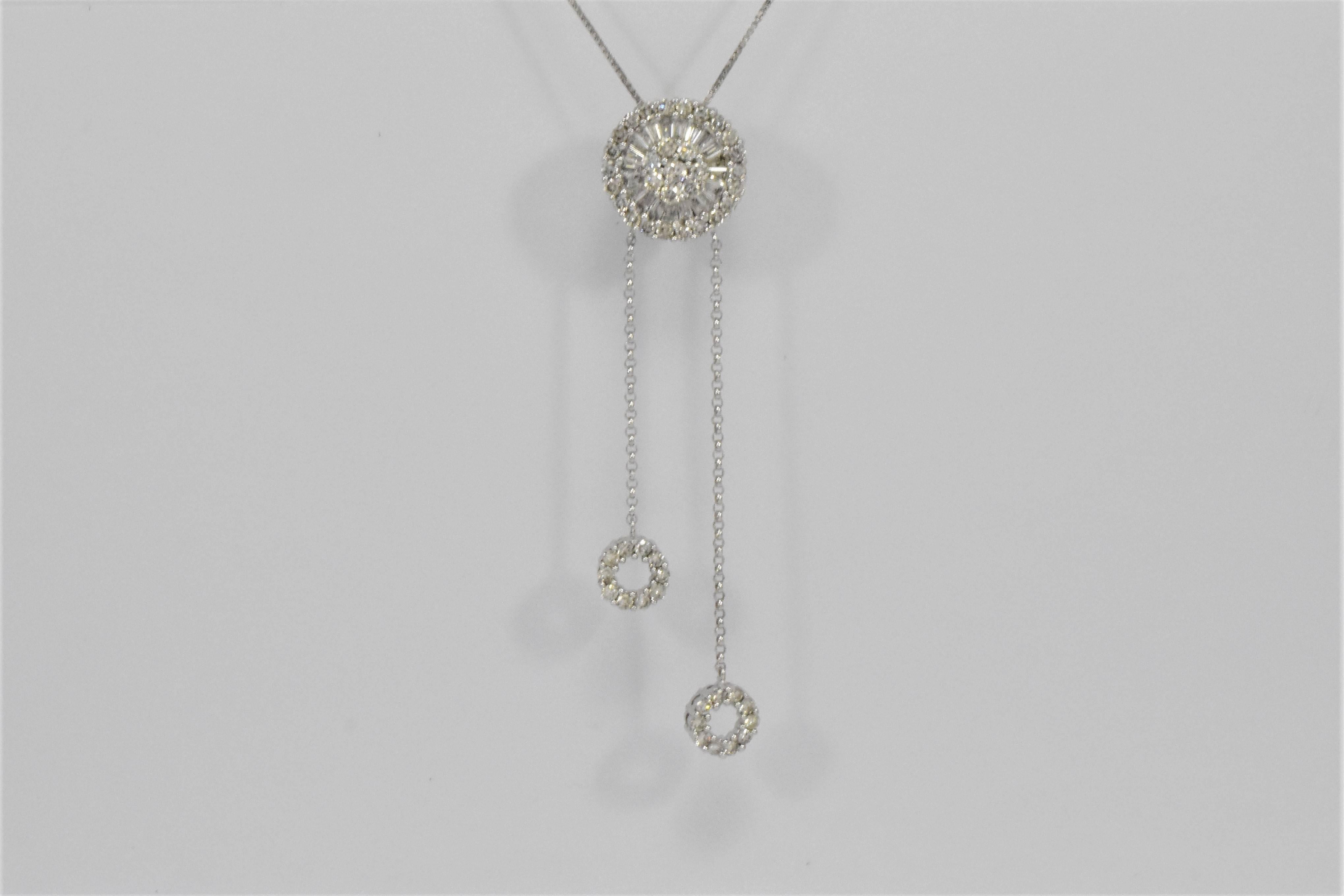 A beautiful cylindrical pendant set with baguette and brilliant cut diamonds, suspending two similarly designed Diamond set roundels on uneven lines. All made in 14ct white gold and suspended on a fine 18ct white gold box-link chain. Selected for