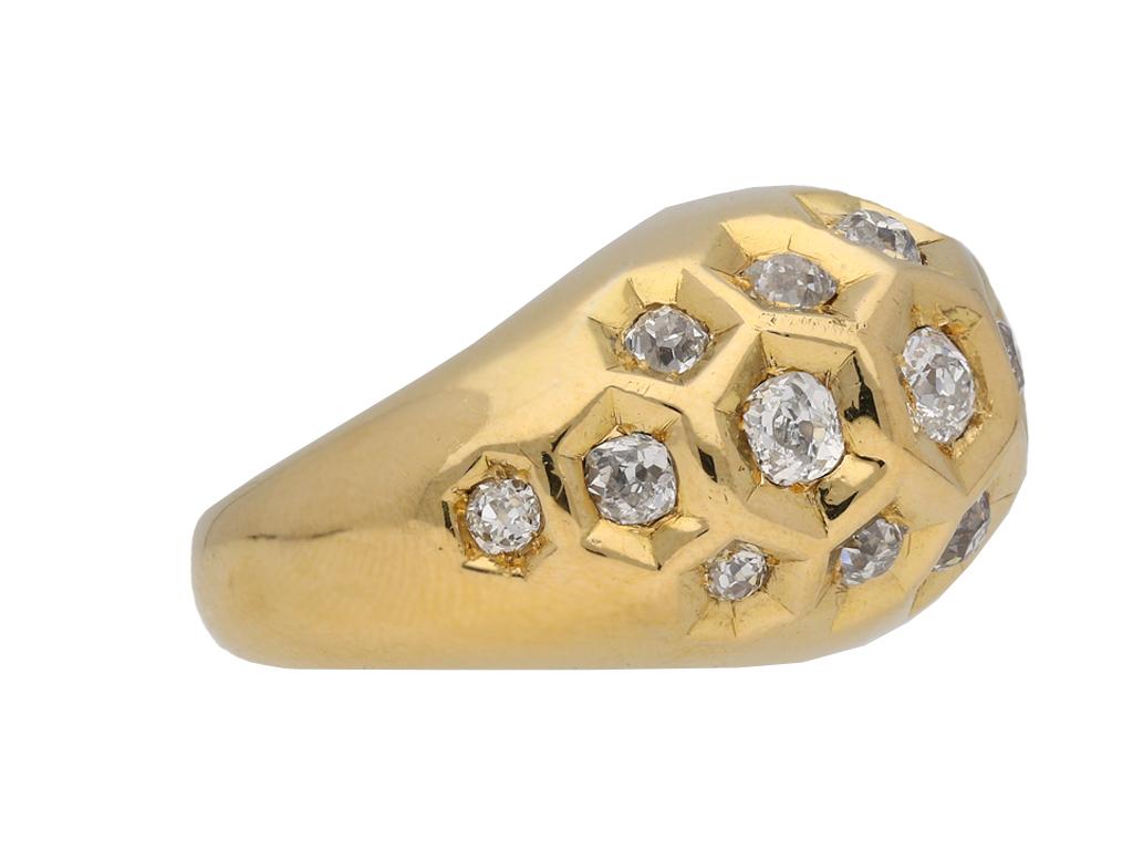 Diamond set honeycomb ring by Cartier, Paris. Set with twenty one cushion shape old mine diamonds graduating from centre in open back rubover settings with an approximate combined weight of 2.10 carats, to a domed bombé three row cluster with