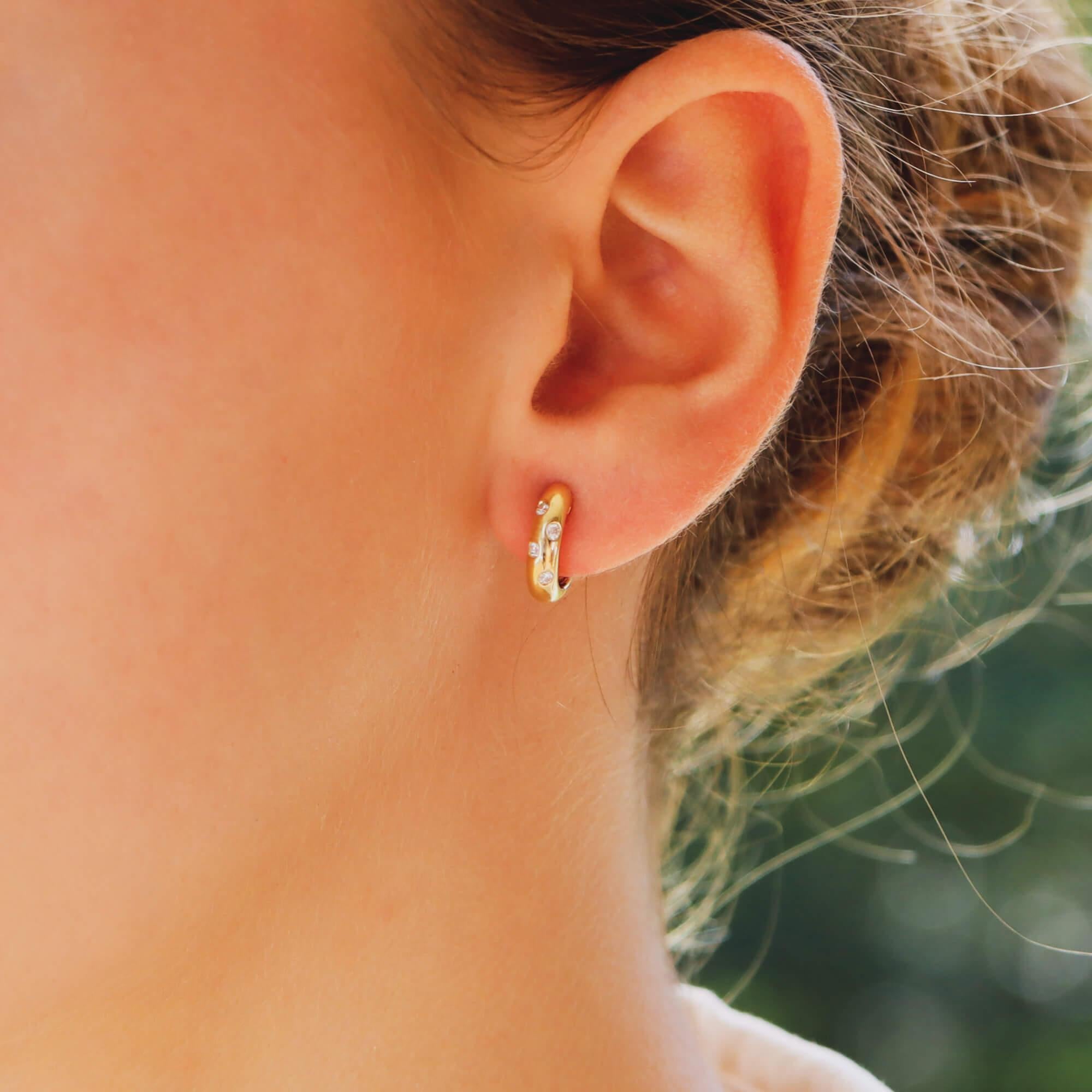 Ein wunderschönes Paar runder Diamantohrringe mit Brillantschliff in 18 Karat Gelbgold.

Diese fabelhaften Reifchen bestehen aus verstreuten Diamanten und sind alle in einem massiven Reifchen gefasst. Sie werden mit einem sicheren Pfosten und einem