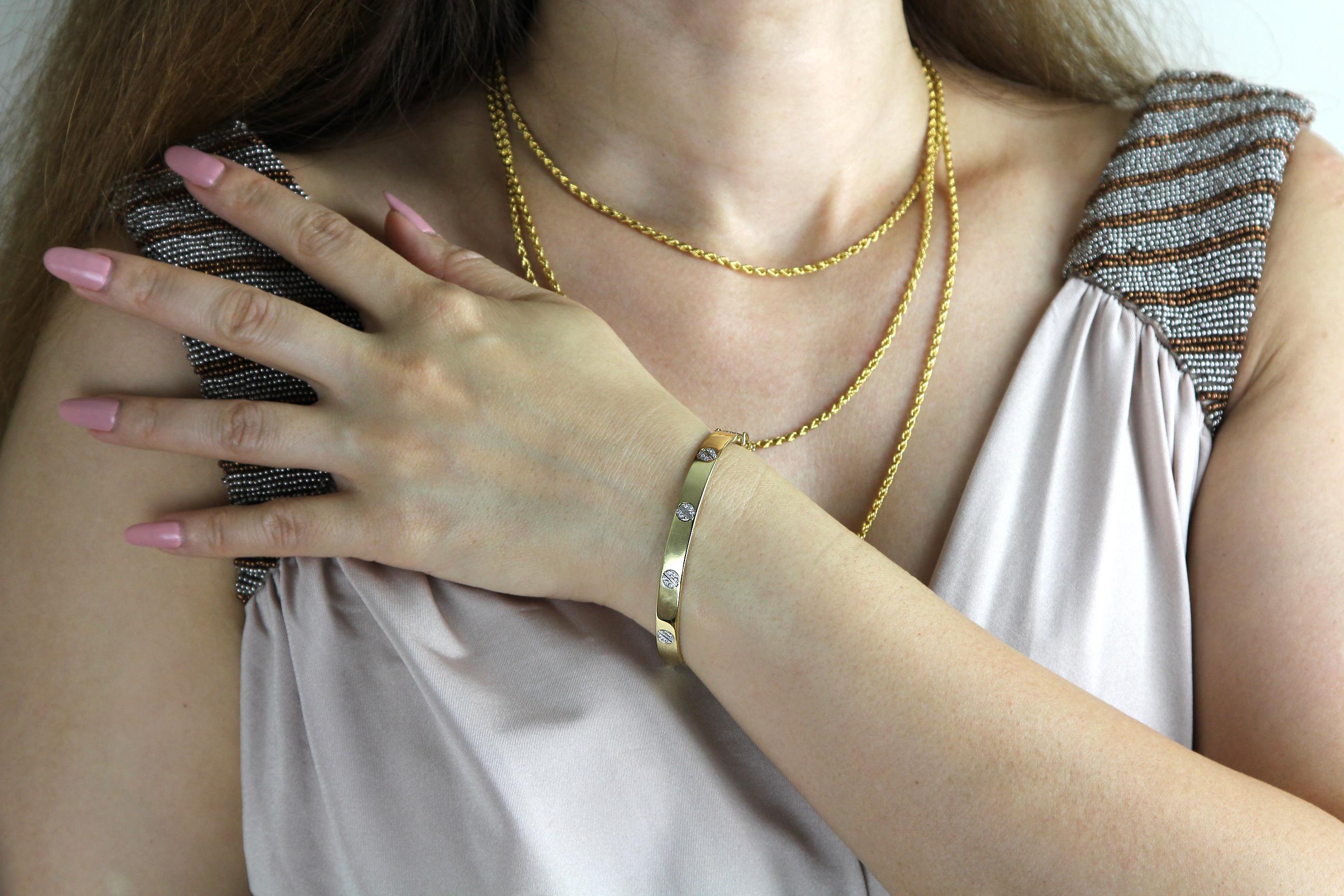 Un magnifique bracelet Love en or blanc et jaune 18 carats serti de diamants, conçu avec le motif iconique de la vis pour une esthétique épurée, élégante et intemporelle. Ce luxueux bracelet en bimétal met en valeur soixante diamants ronds de taille