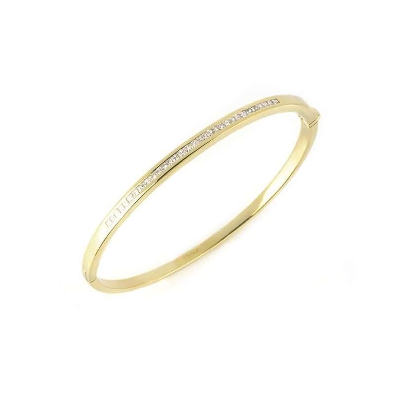An 18k yellow gold diamond set hinged bangle. The bangle is comprised of a single row of channel set, princess cut diamonds totalling approximately 0.64ct, predominantly colour H and VS clarity. The 4mm bangle would fit a wrist of up to 17cm and has