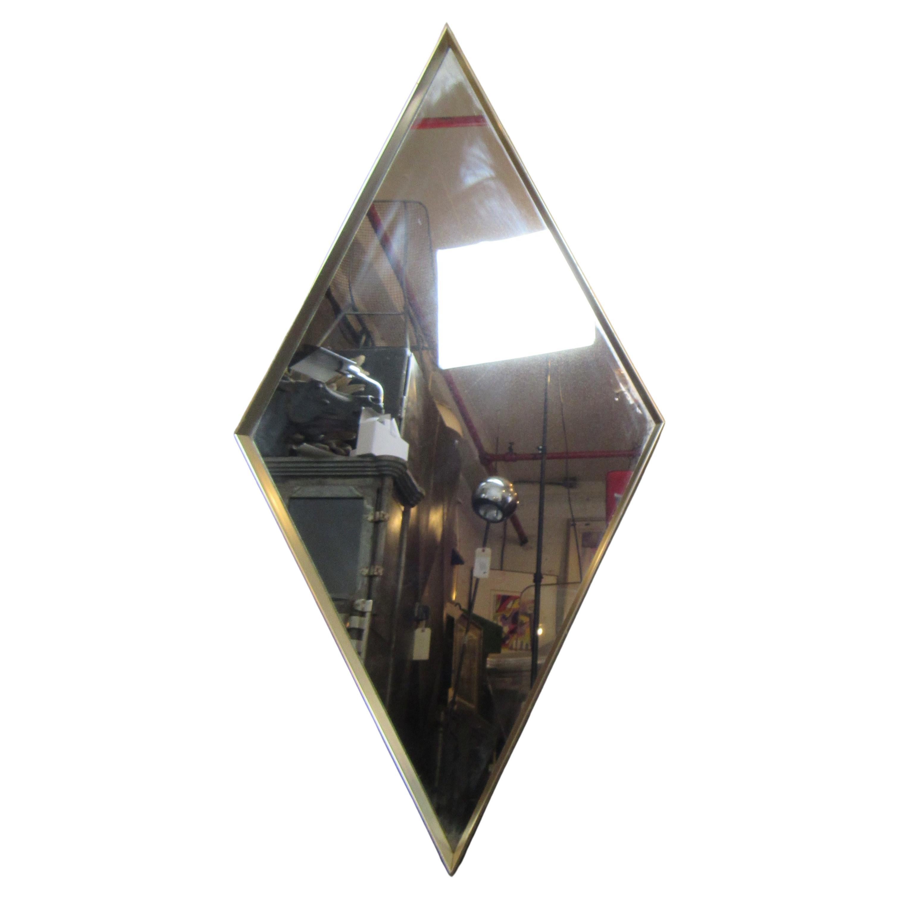This vintage diamond-shaped wall mirror is accented by a metal frame, and is perfect for placing in a range of settings. 
Please confirm item location with seller (NY/NJ).
