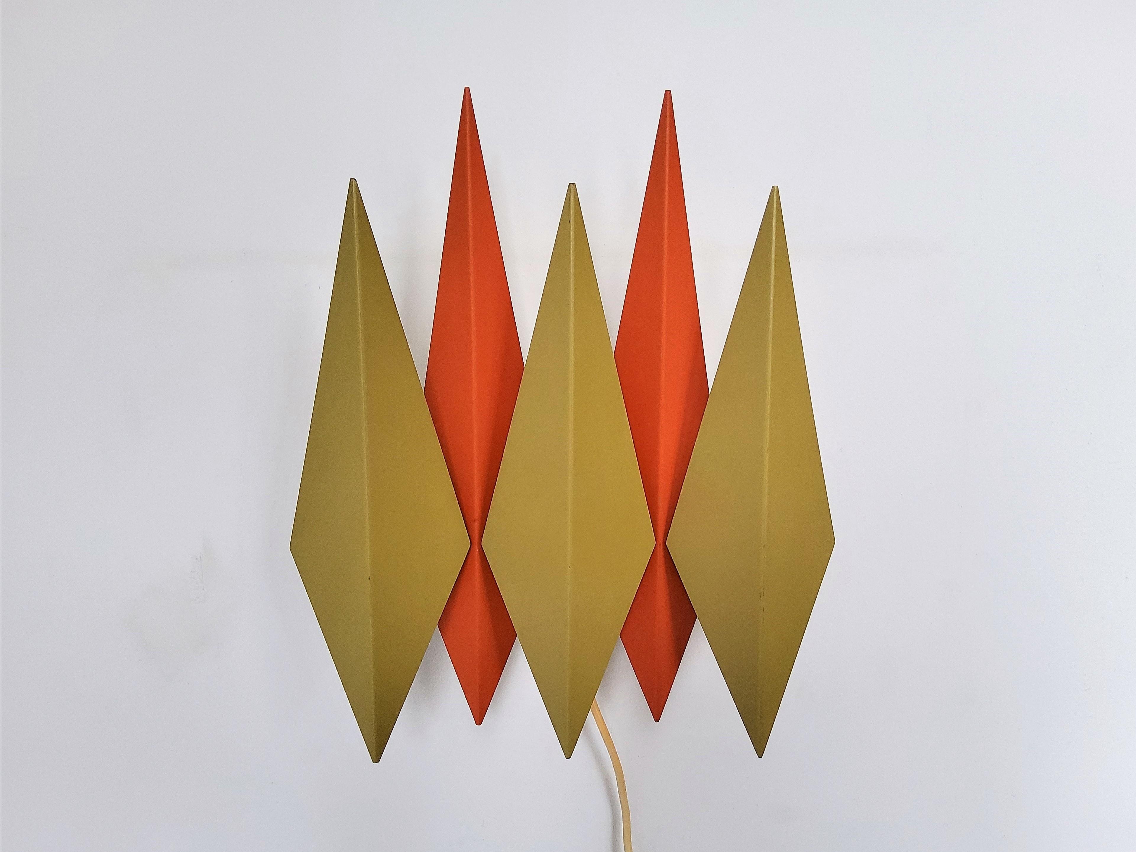 This beautiful wall lamp was designed by Svedn Aage & Holm Sørensen for Holm Sørensen & Co in Denmark in the 1960's. It is made out of 5 diamond shaped parts in an olivegreen and orange colour. A true Danish design from the 1960's. This lamp is in a