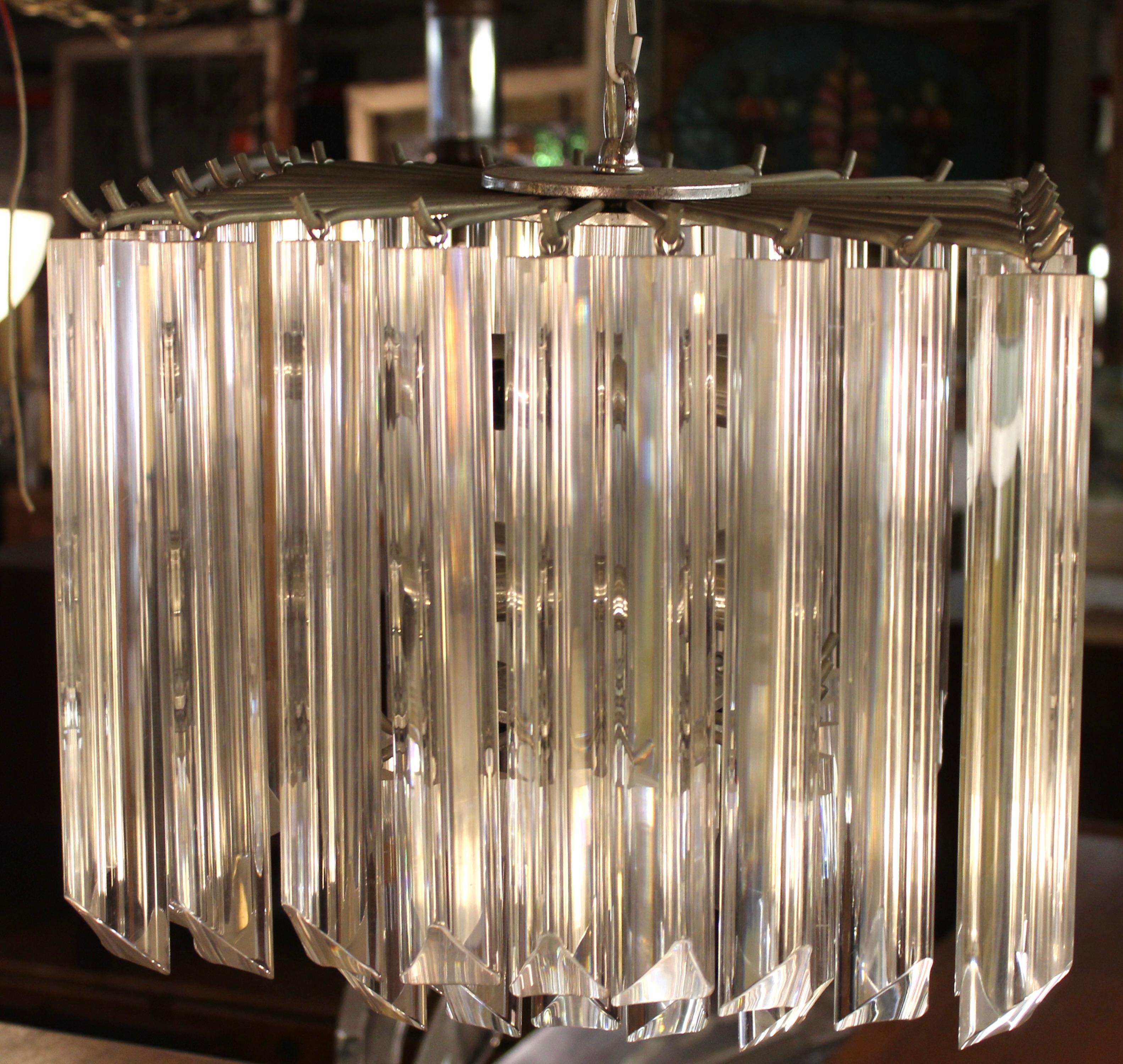 Esta lámpara de araña escalonada presenta filas de prismas de lucita transparente colgados de un marco cromado. Detrás de los prismas triangulares de cristal se ocultan diez tomas de candelabro.
Por favor, confirme la ubicación NY o NJ