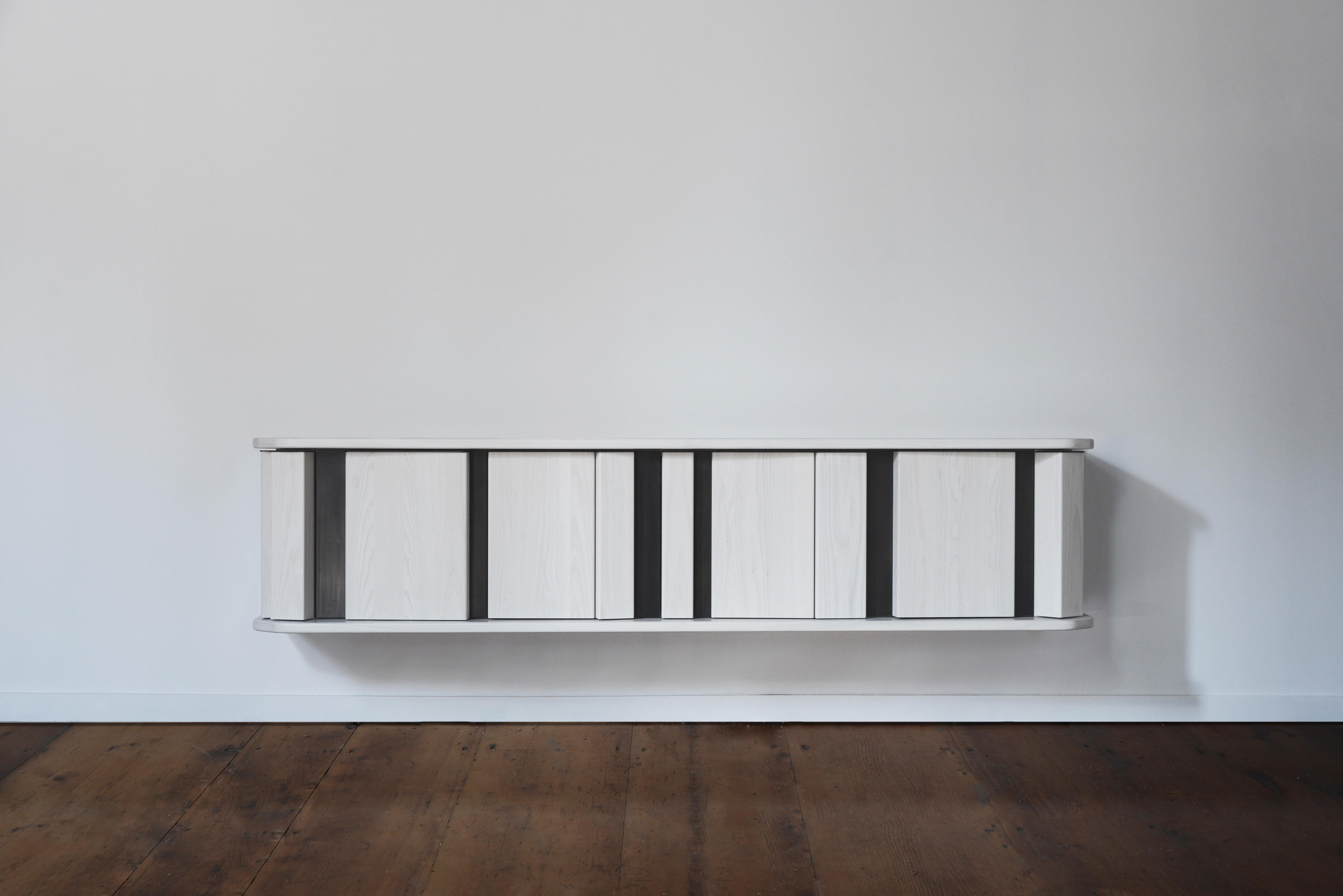 The diamond sideboard plays with different planes. A collection of rectangular columns placed at random angles and depths forms a facade interrupted by two thick horizontal planes of solid wood. This array of volumes serves as doors to a fully