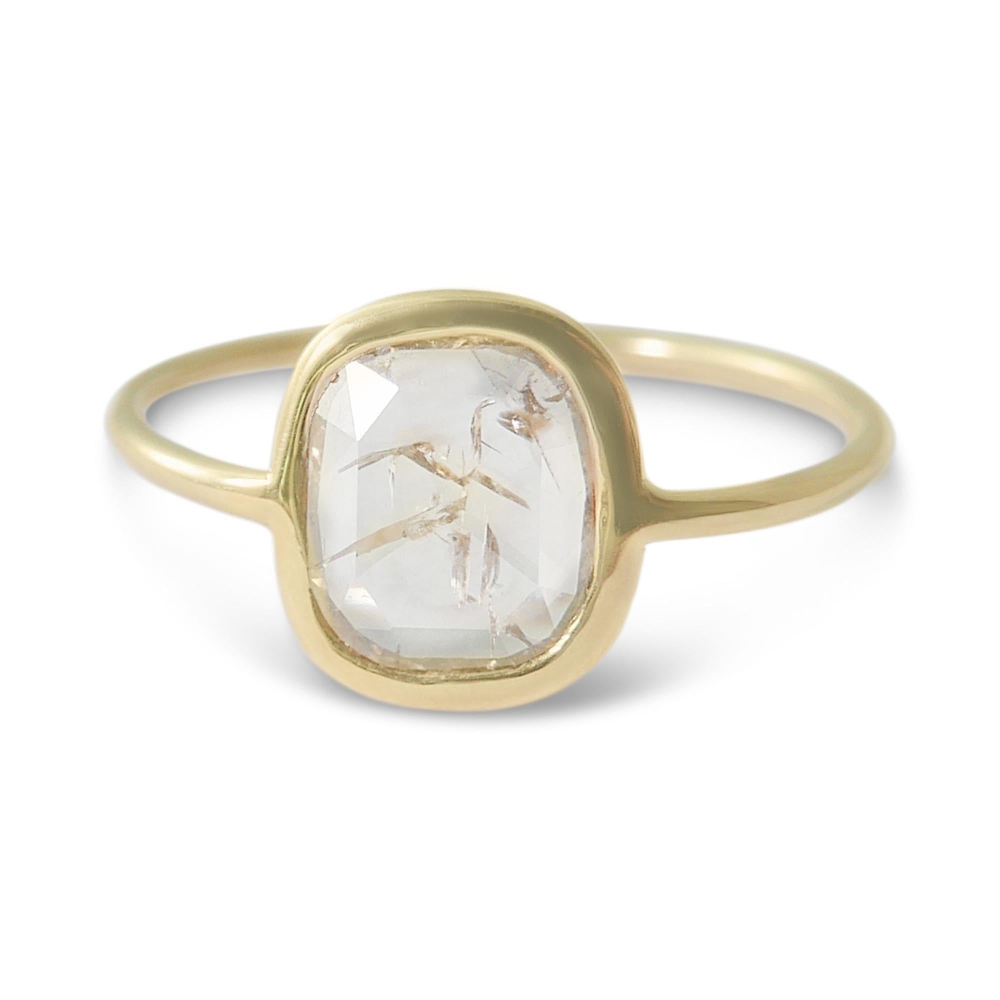 This diamond ring features a pale cognac oval shaped rosecut diamond set in a 18-karat yellow gold bezel on a slim band.  Weighing approximately 0.8 carat, the diamond is a rustic rosecut stone in a slightly squared oval shape and contains unique