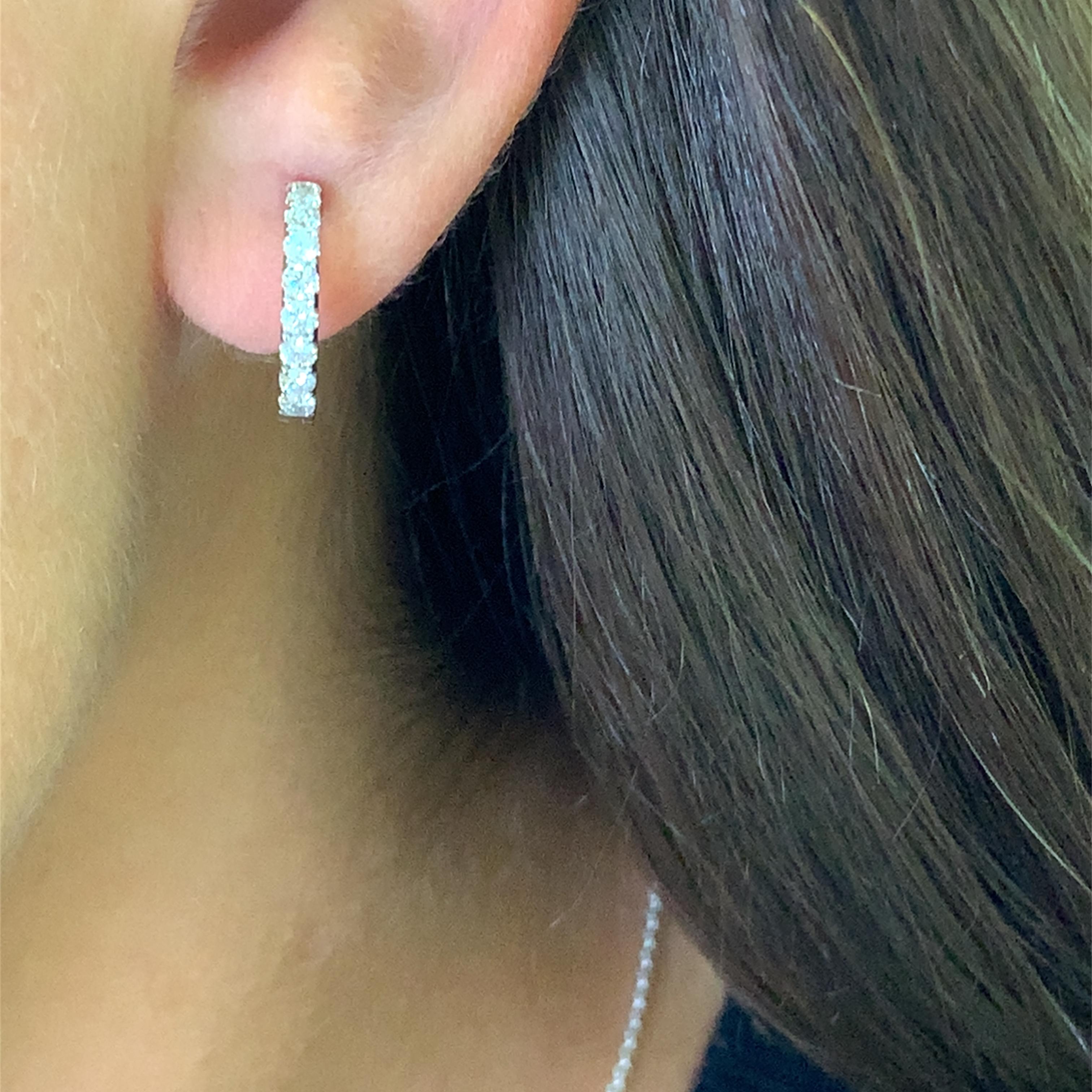 Elevate your everyday style with these refined 18k white gold hoop earrings. Each earring is meticulously set with round brilliant-cut diamonds, creating a continuous sparkle. These classic hoops blend seamlessly with any ensemble, adding a touch of