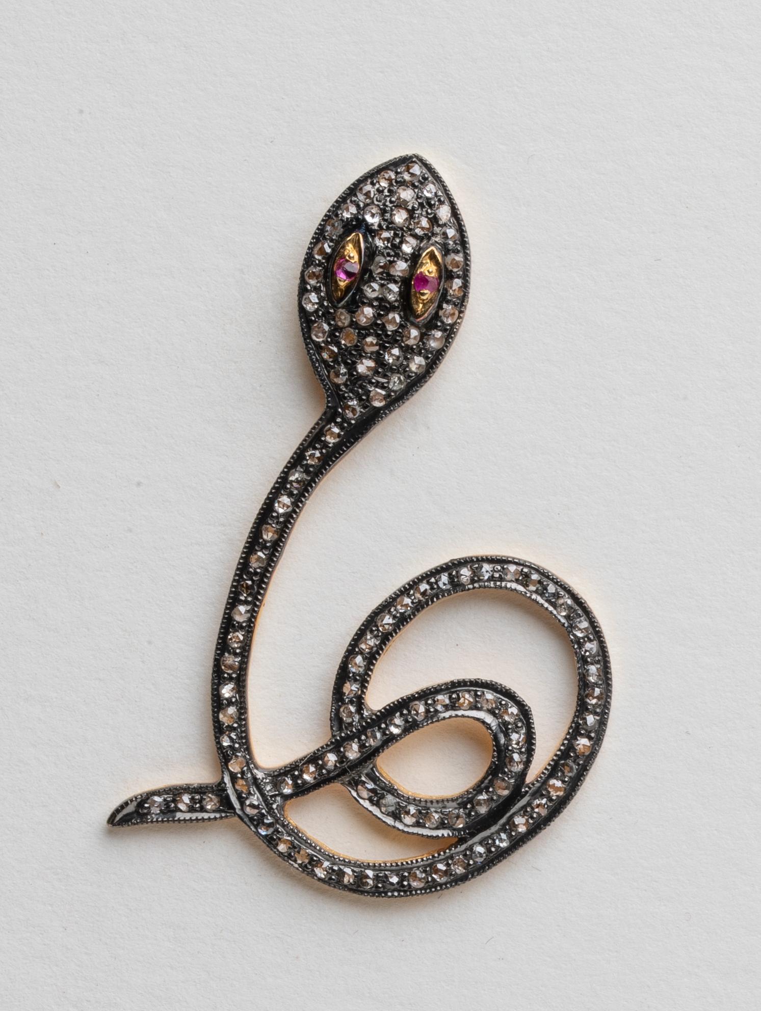 A pair of coiled snake earrings with round, brilliant cut diamonds set in rhodium plating with faceted ruby eyes.  18K gold post for pierced ears.  Total weight of diamonds is 1.43 carats.