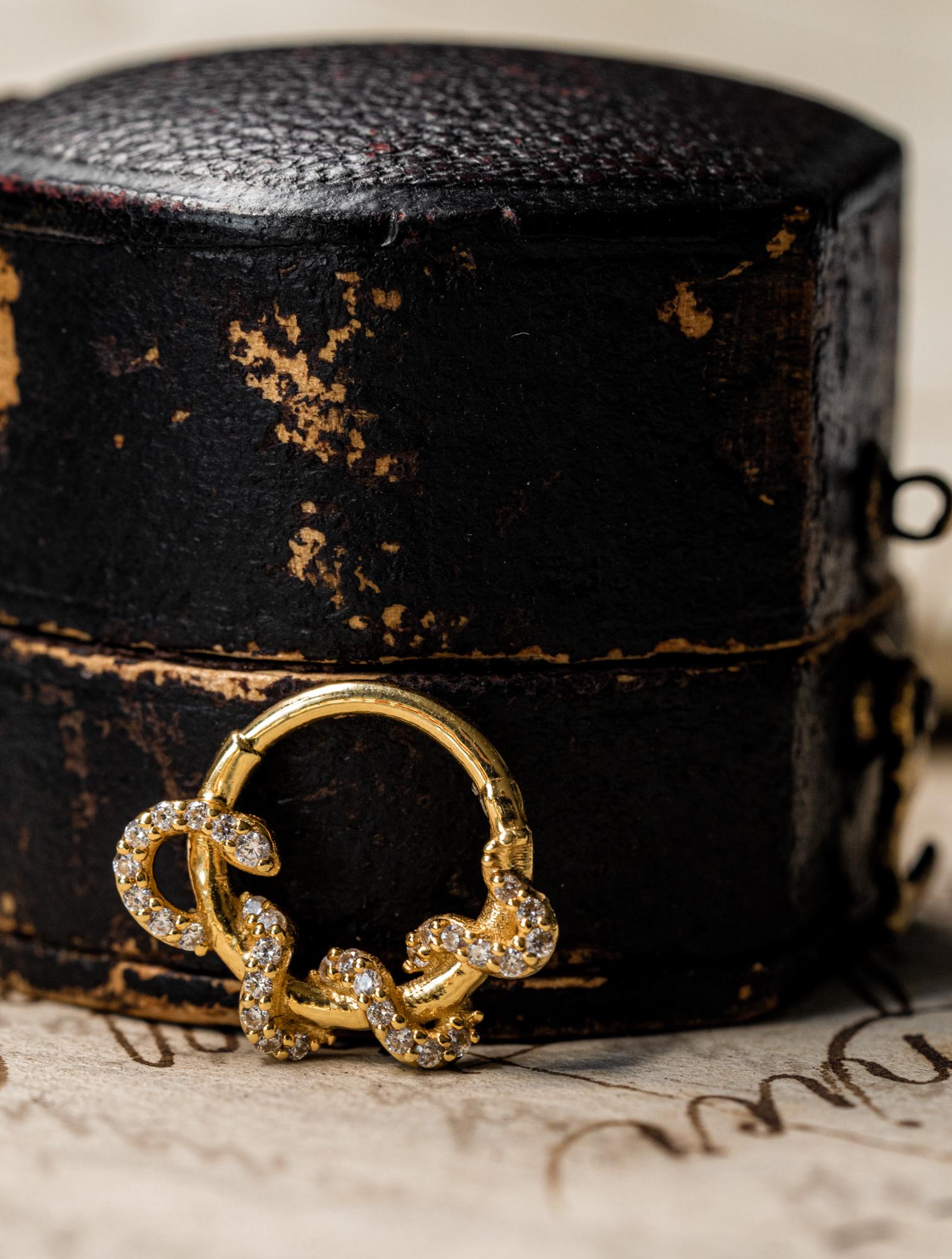 Single diamond snake earring in solid 14k gold. The earrings is set with 31 CZ diamonds with a total weight of 0.11 CT.
Can be worn as a nose or ear piercing. If you would like to order a pair, please refer to another listing in our shop. This