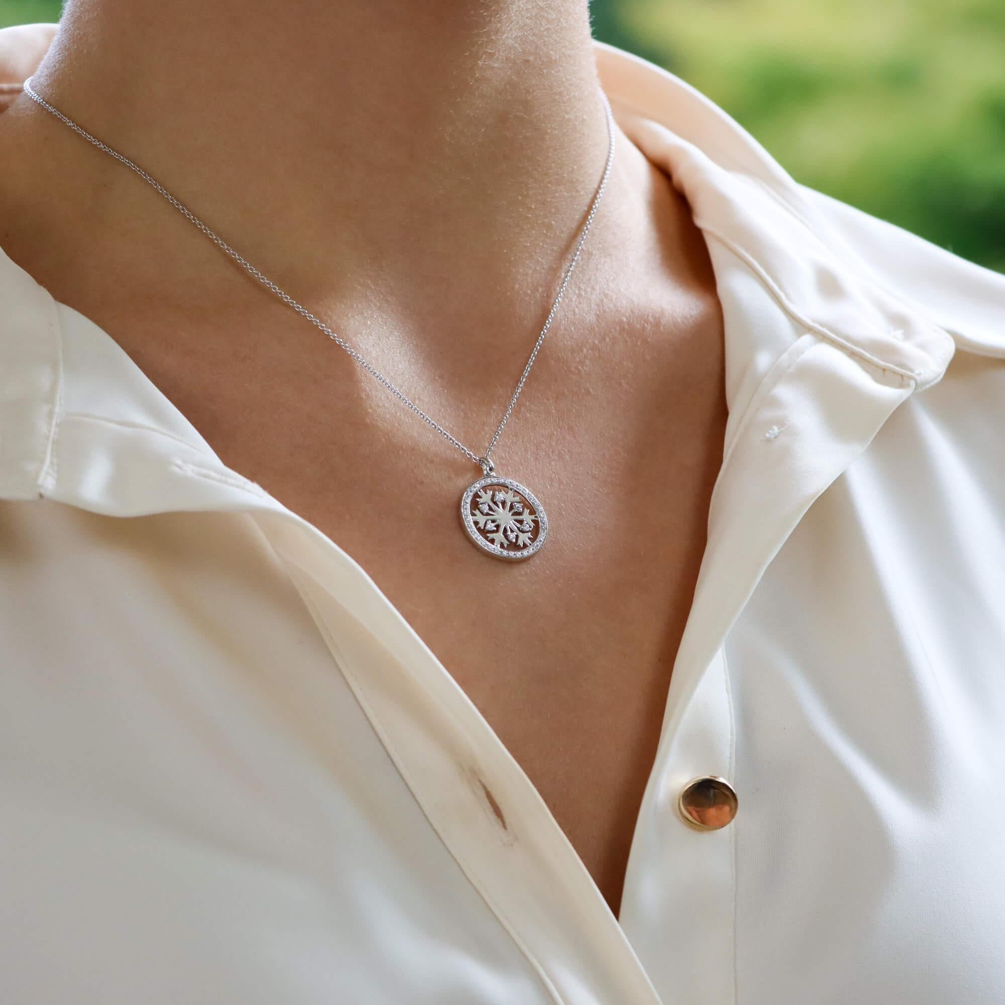 A beautiful diamond set snowflake pendant set in 18k white gold.

This pretty little pendant is centrally set with a polished white gold snowflake which is haloed by a ring of millegrain set diamonds. Amongst the snowflake we see 6 more round