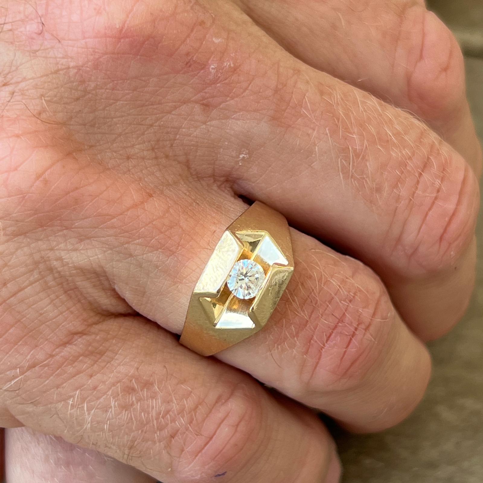 Gents diamond solitaire ring handcrafted in 14 karat yellow gold. The ring features a approximately .40 carat round brilliant cut diamond tension set between two gold ridges. The diamond is graded H-I color and SI clarity.  The ring measures 12mm in