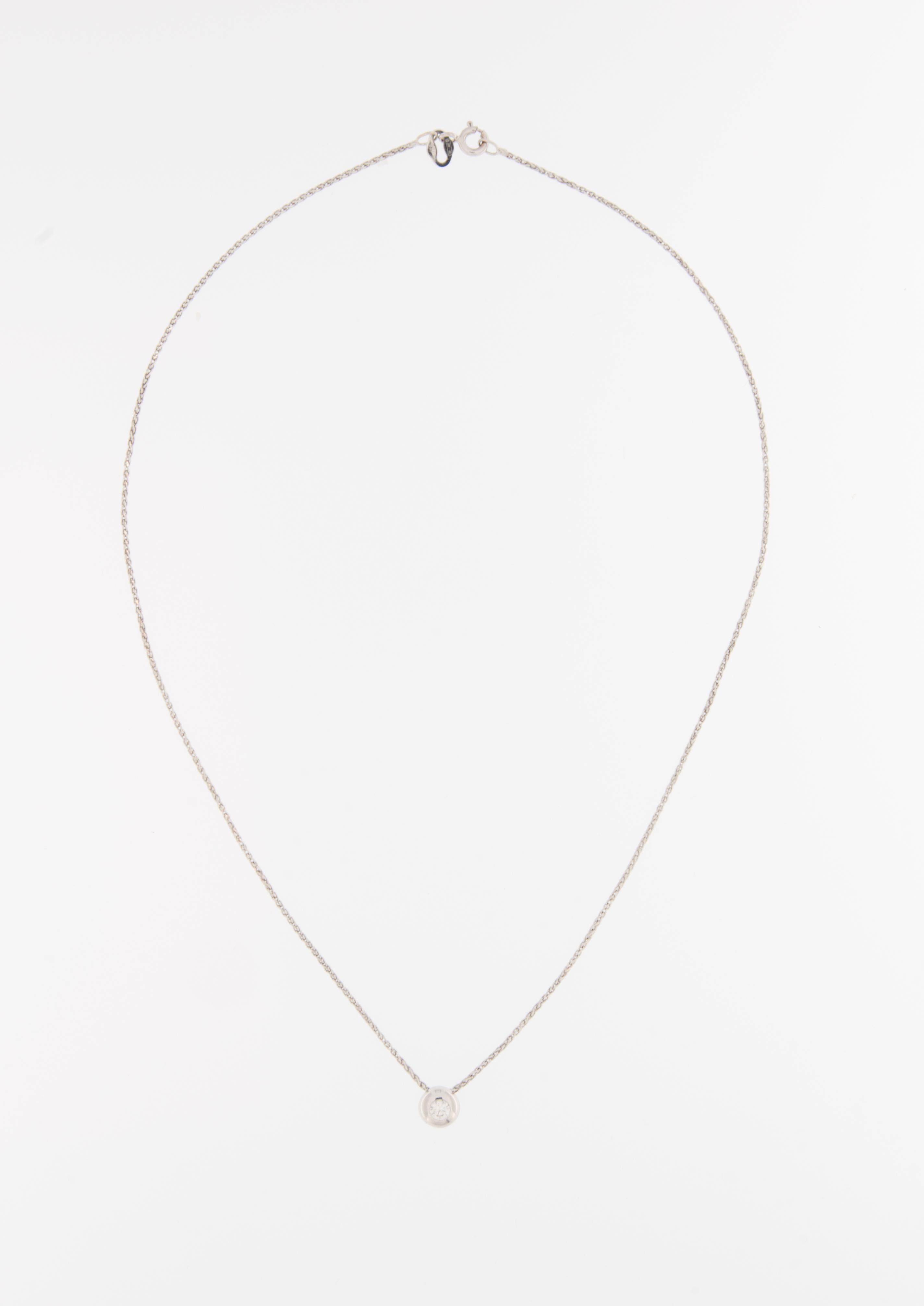 The Diamond Solitaire Necklace with Chain is a captivating and minimalist piece of jewelry, radiating elegance and sophistication. This necklace features a single, dazzling diamond set in a classic solitaire design, suspended from an 18-karat white